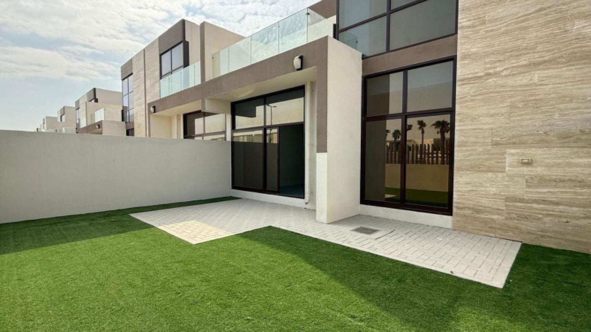 "Spacious Elie Saab townhouse kitchen with large windows, Meydan community, for sale.",Vacant Elie Saab townhouse exterior with lawn, Meydan community, next to pool and park