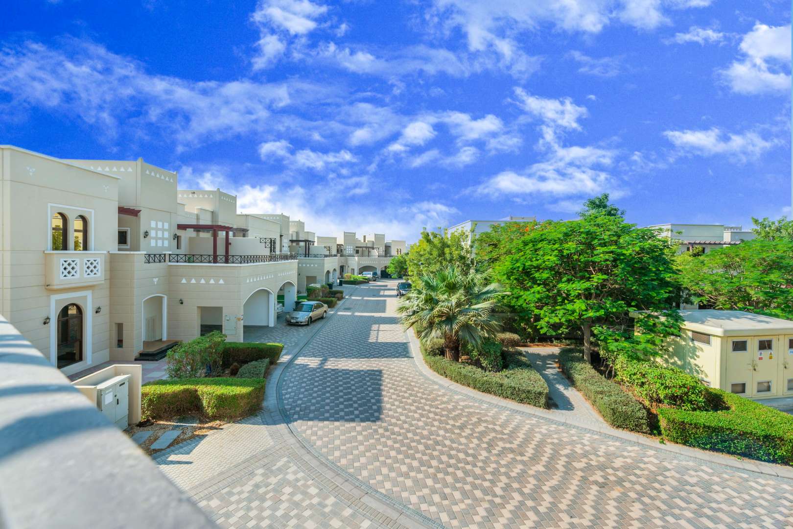 "Al Salam Mudon community townhouse street view with lush greenery and clear blue sky.",Spacious bathroom in Al Salam townhouse, Mudon Community, featuring modern fixtures and dual sinks