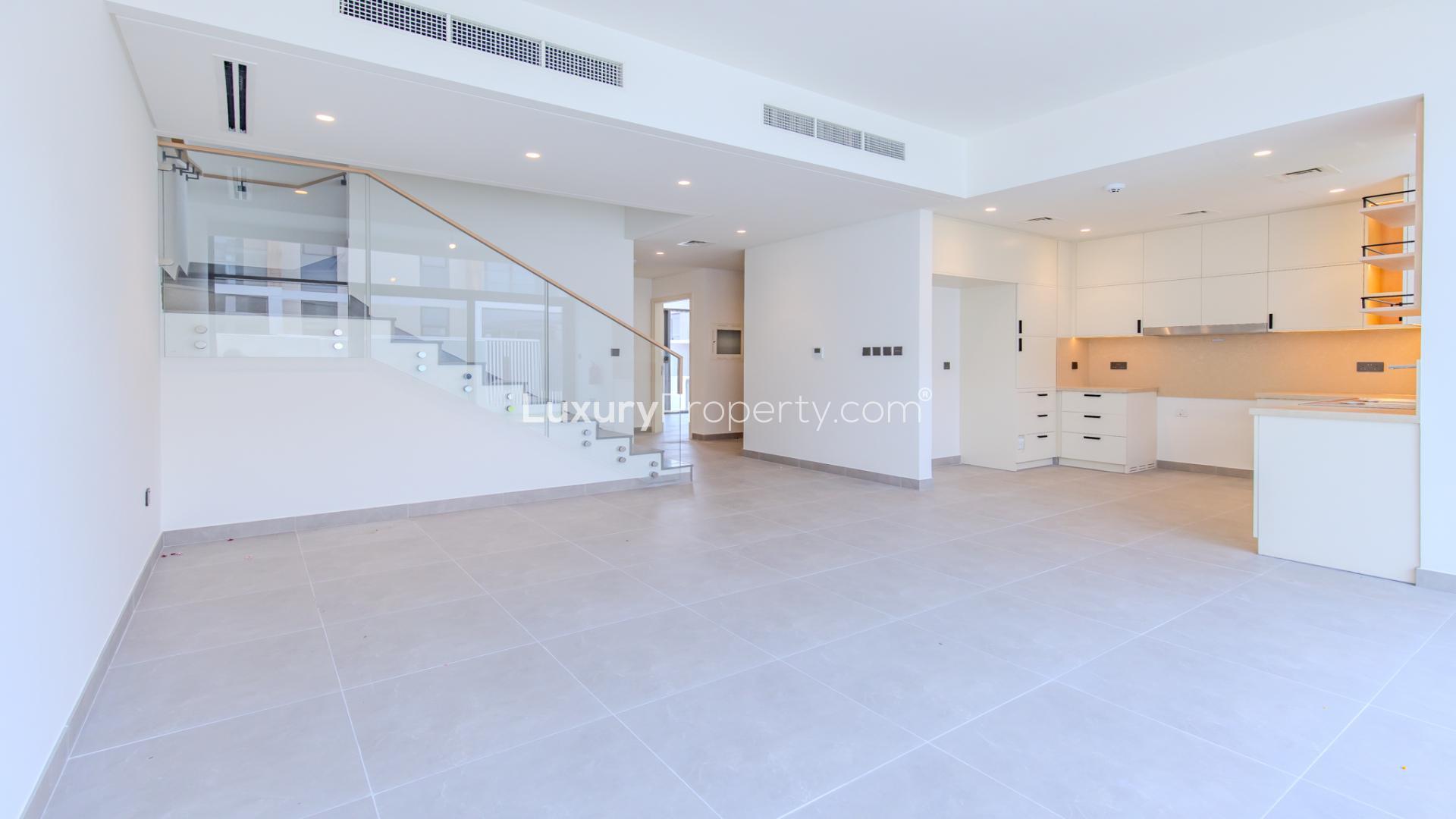 "Balcony view of modern townhouses in Ruba, Arabian Ranches 3, Dubai real estate for sale.",Modern open-plan kitchen and living area in Ruba townhouse, Arabian Ranches 3