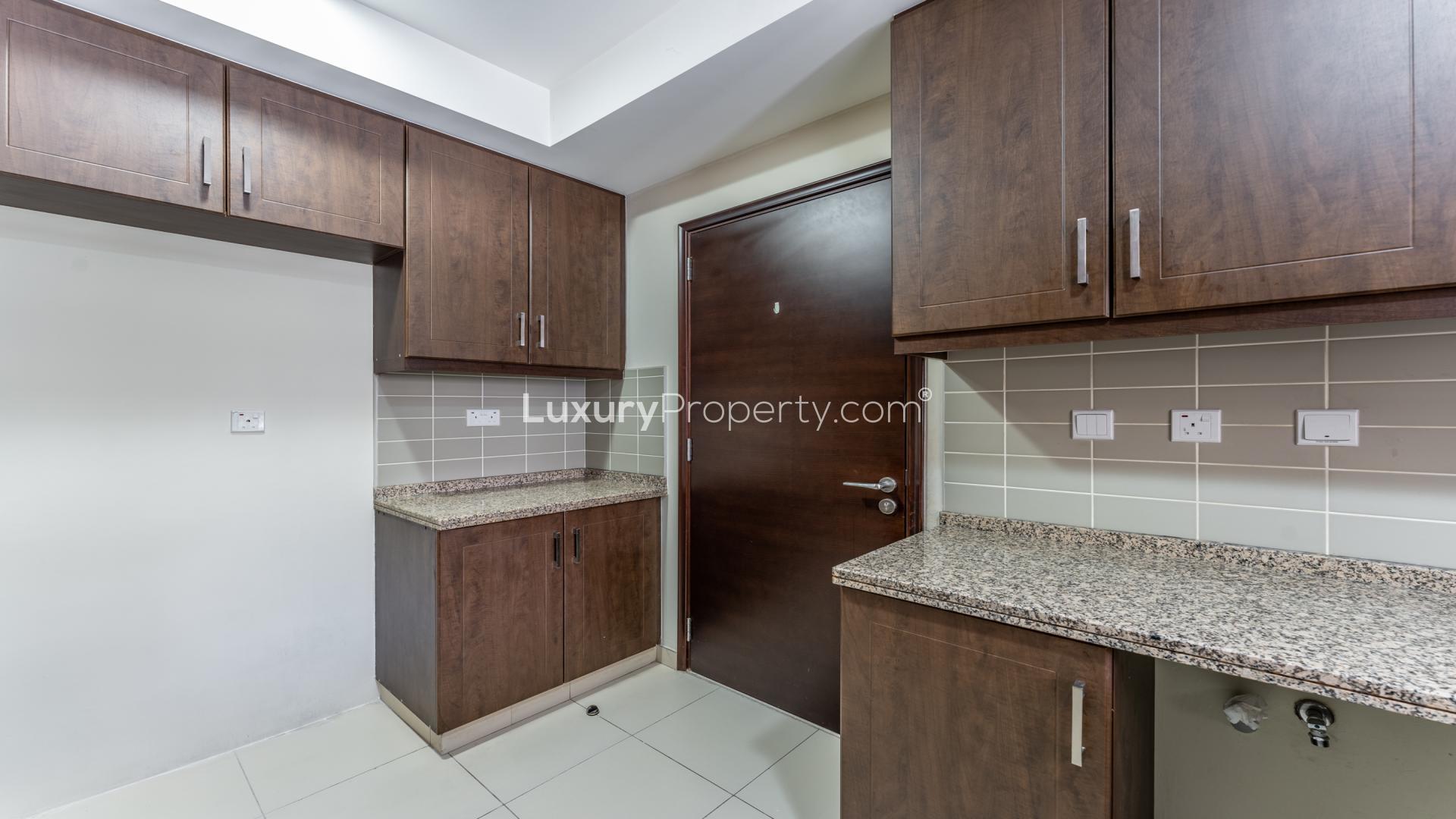 Modern kitchen with dark wood cabinets in 4-bedroom villa, Reem Mira, Dubai