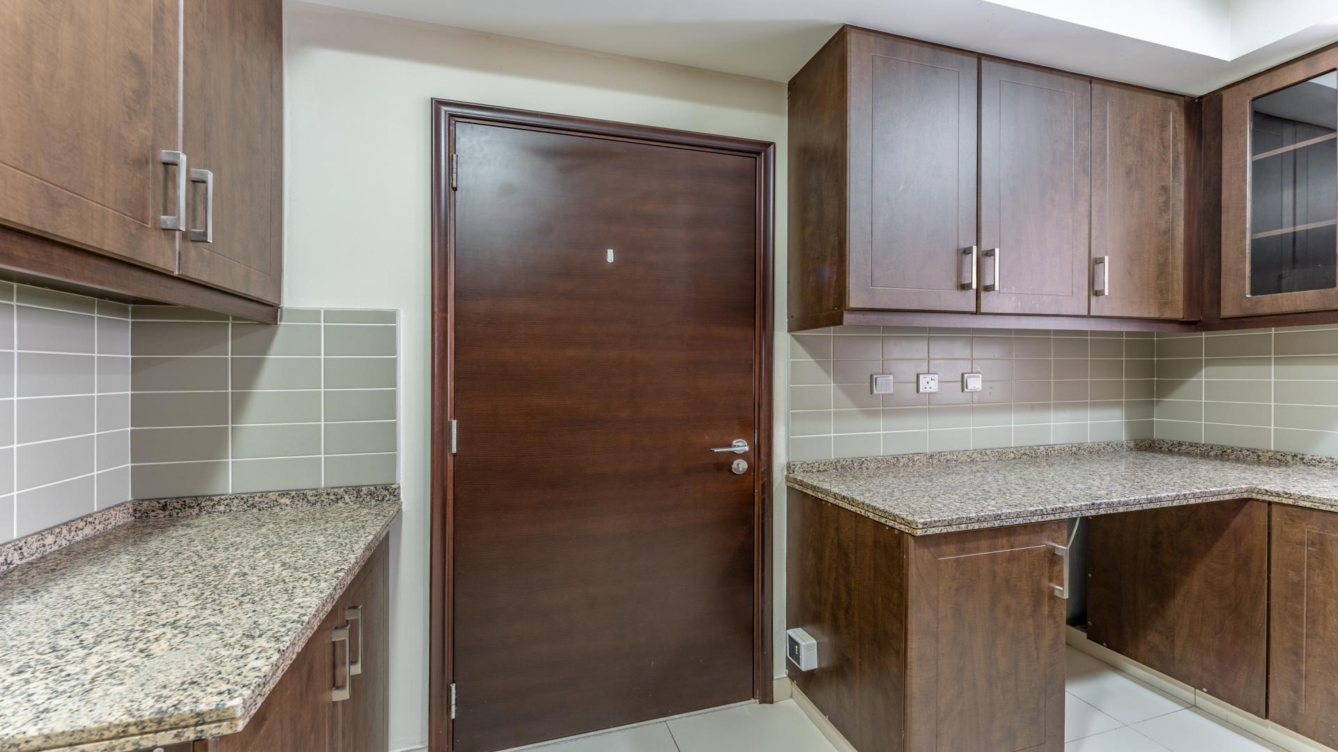Kitchen with dark wood cabinets in Reem Mira 4-bedroom villa, Dubai