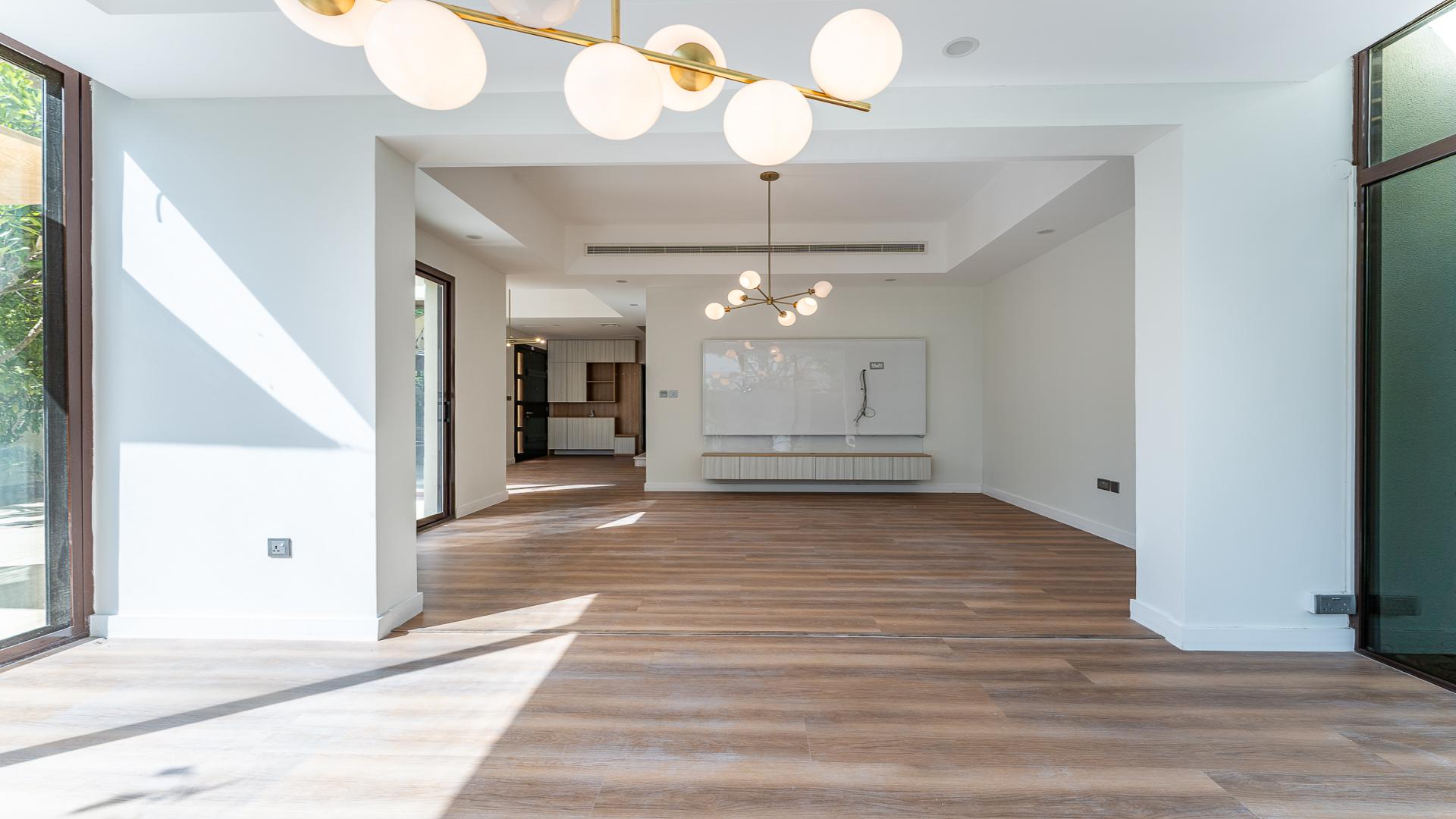 Bright living room in Mira townhouse, wooden flooring, large windows, modern chandelier, Reem community