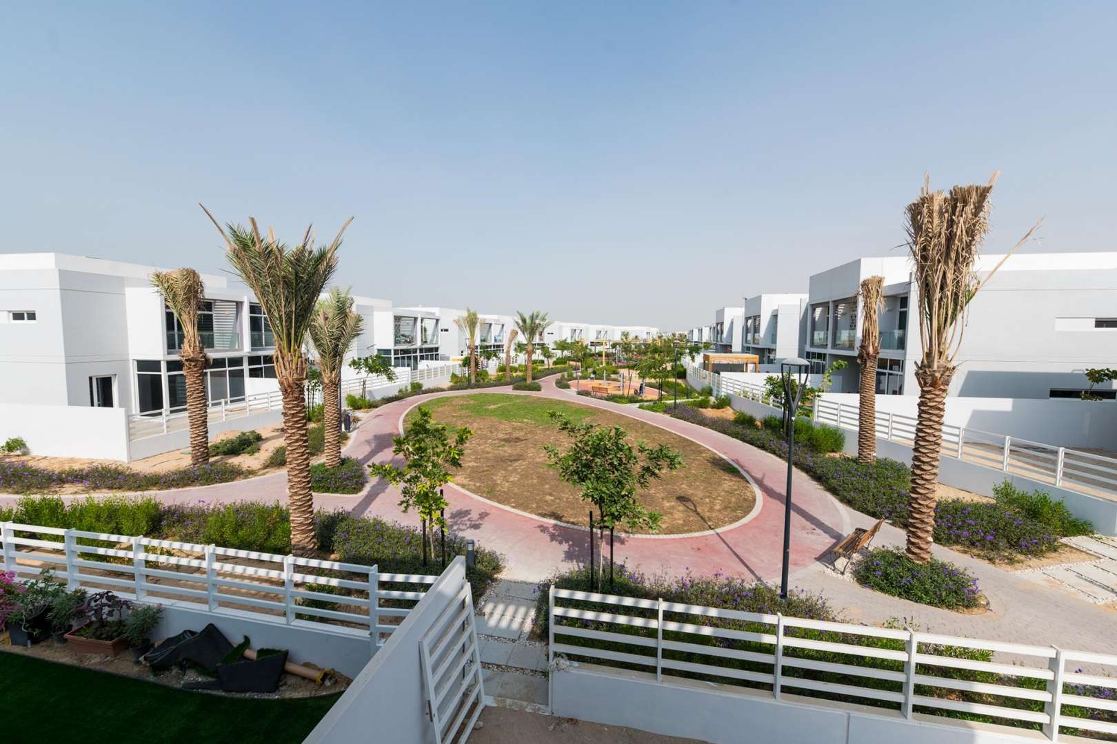 Pathway view of modern Arabella Townhouses in Mudon, surrounded by lush greenery