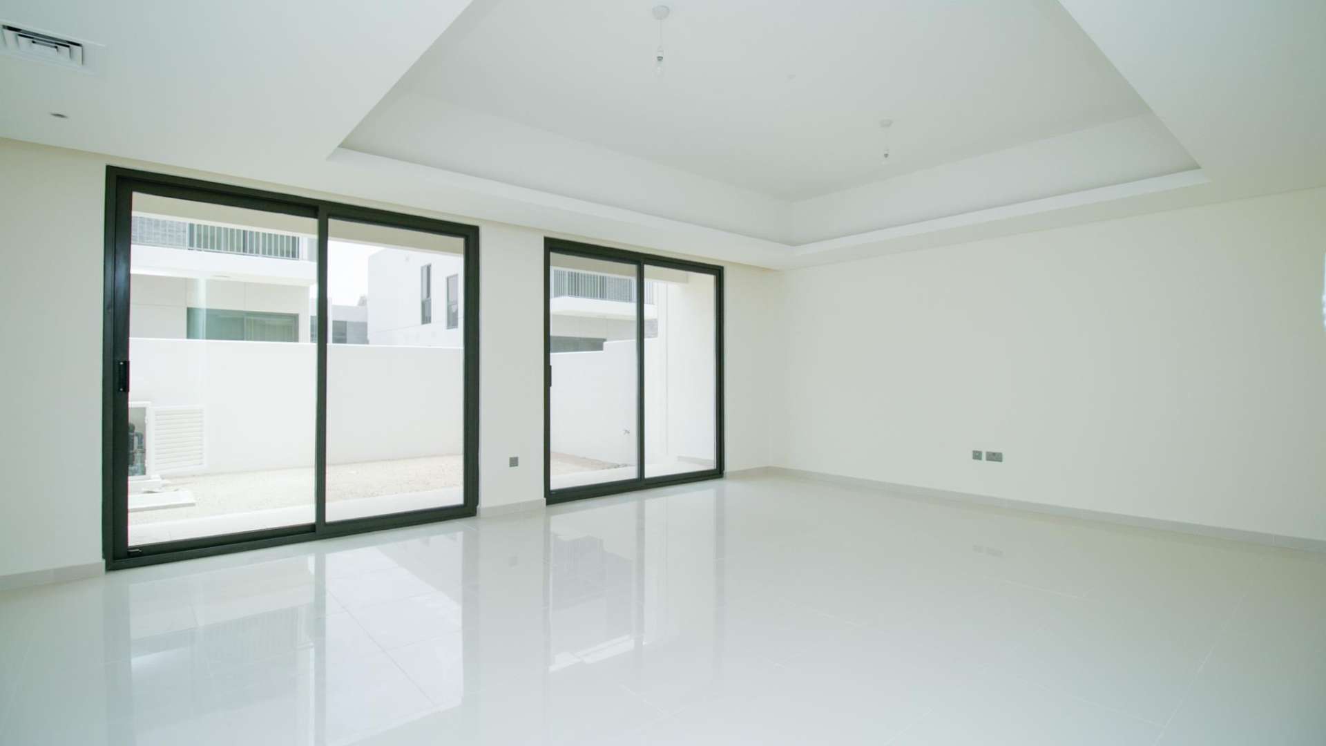 Empty living room with large windows in Claret townhouse, Damac Hills 2 for sale