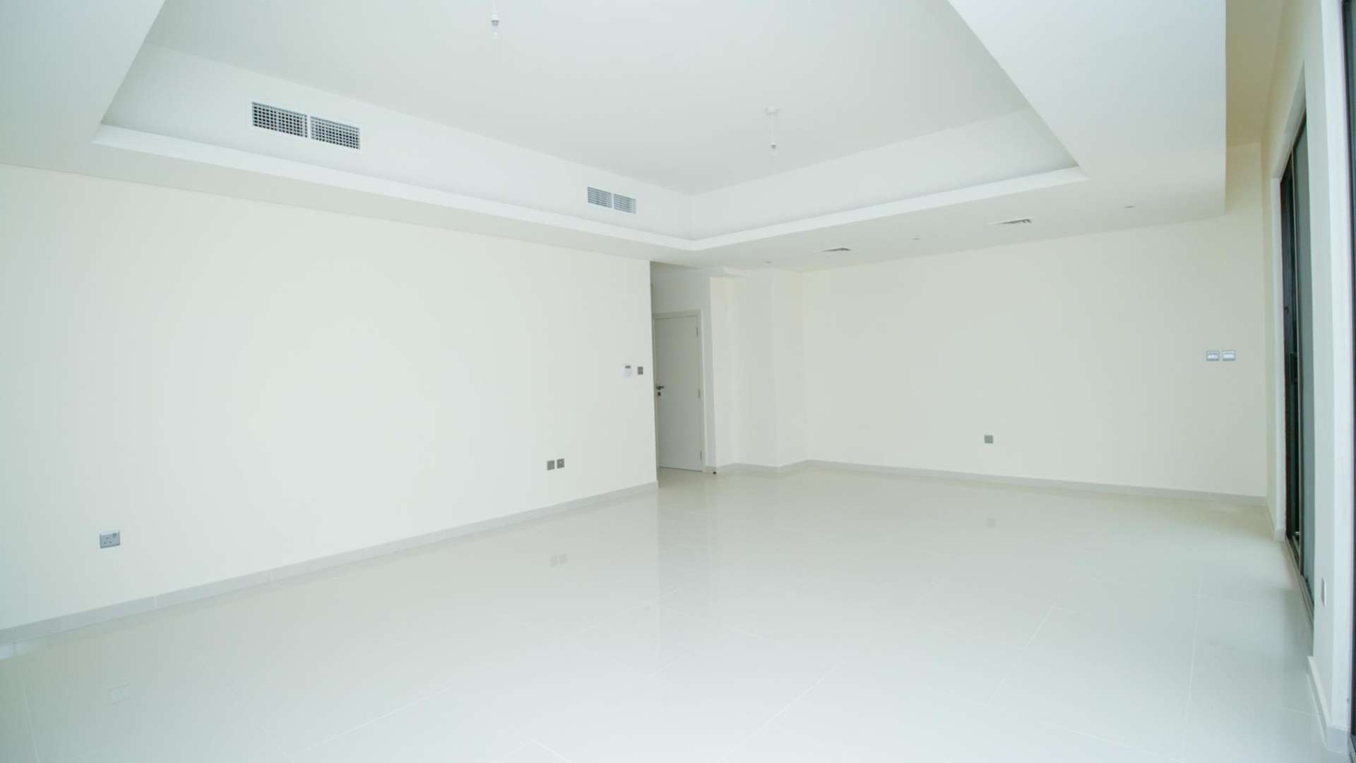 Bright living room in Claret townhouse, Damac Hills 2, with large sliding glass doors