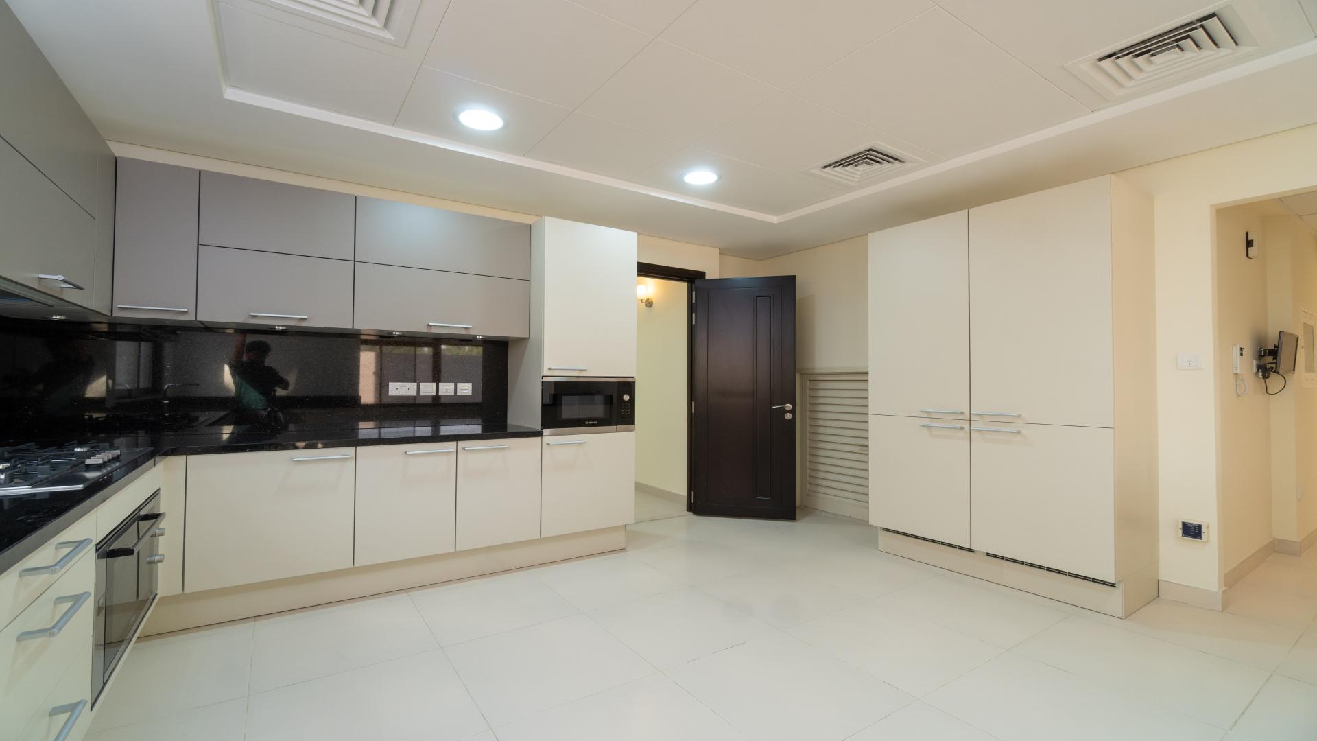 Modern kitchen in four-bedroom Meydan townhouse for sale, featuring sleek cabinetry and appliances