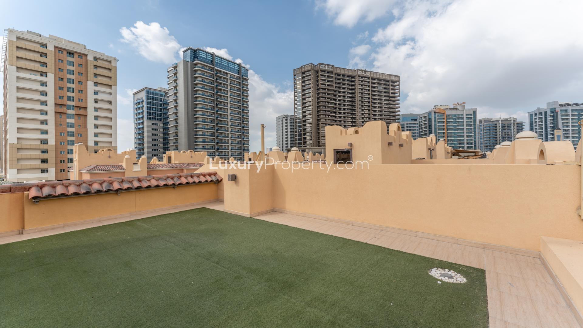 Spacious living room with large windows overlooking garden in Bloomingdale townhouse, Dubai Sports City