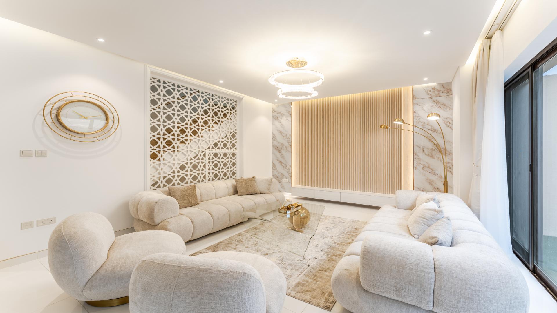 "Spacious patio of upgraded townhouse for sale in Bloomingdale, Dubai Sports City.",Elegant living room in upgraded Bloomingdale townhouse, Dubai Sports City. Modern decor and lighting