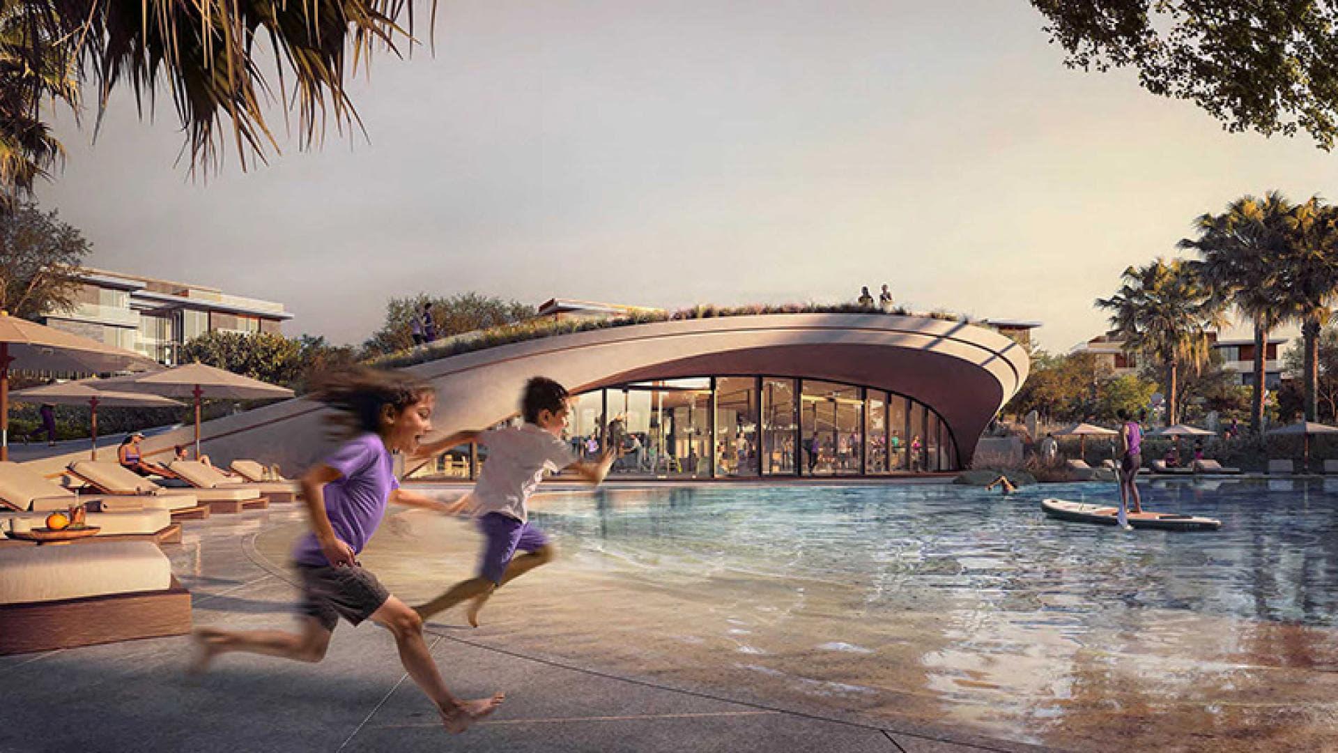 Children playing by pool in Haven by Aldar community, Dubai Land townhouse development