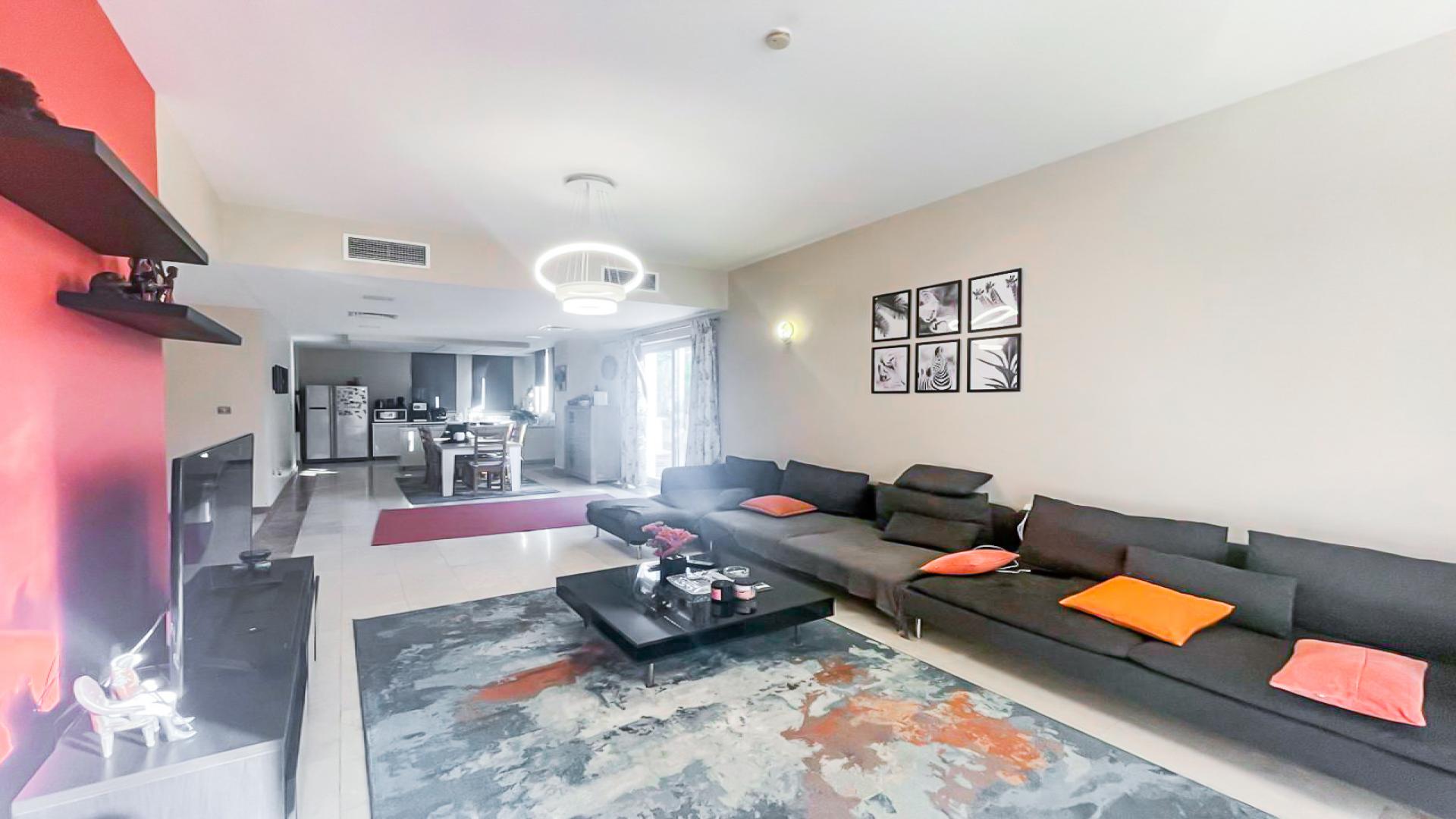 Living room in 4-bedroom villa, Jumeirah Village Circle, with modern decor and vibrant accents
