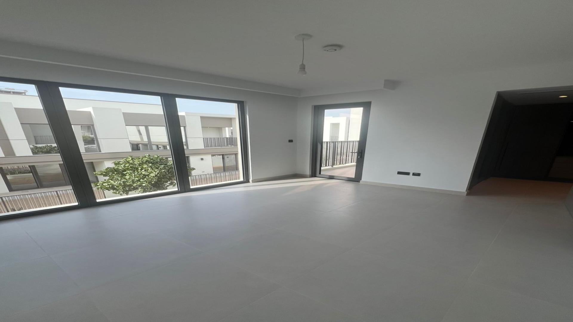 Spacious living area in Aura Gardens townhouse, Tilal Al Ghaf, featuring modern open kitchen design