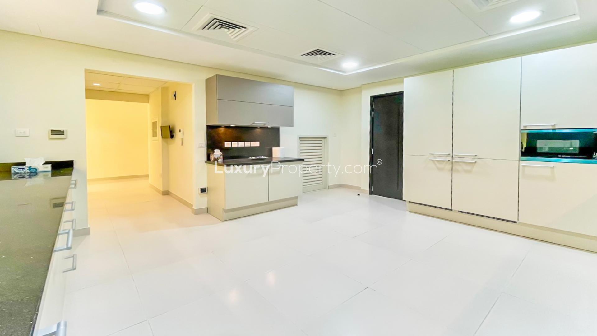 Contemporary kitchen in 4-bedroom Meydan townhouse, featuring sleek cabinetry and modern appliances