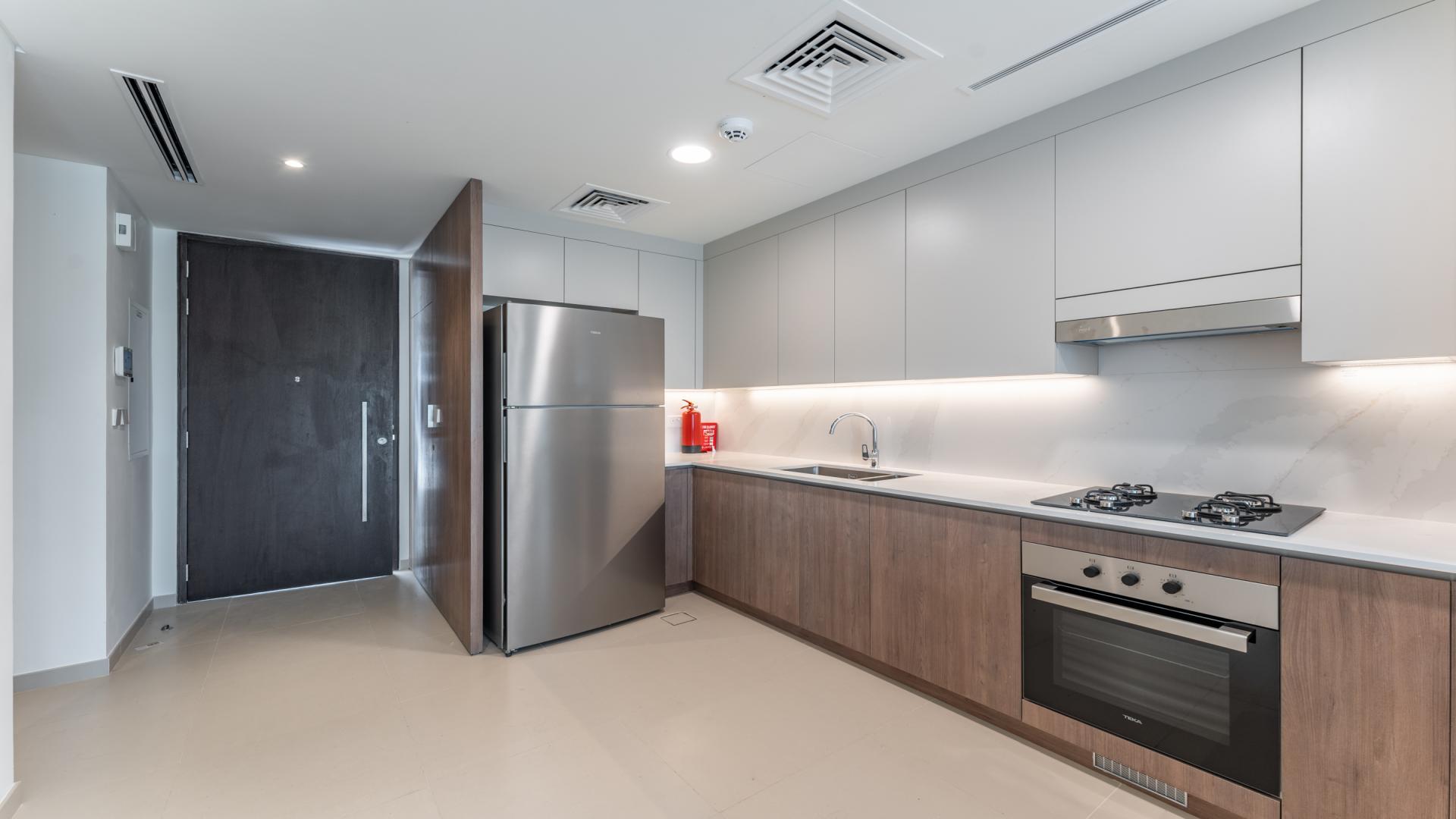 Modern living room with open kitchen in Tilal Al Ghaf villa, Elan community