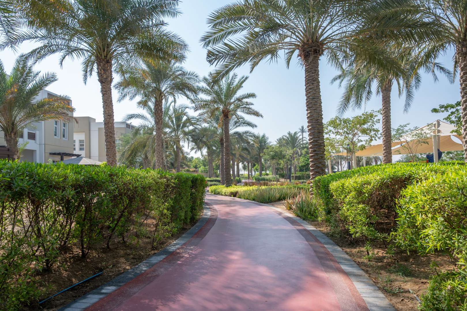 Pathway through lush park in Naseem, Mudon community, near 4-bedroom townhouse for sale