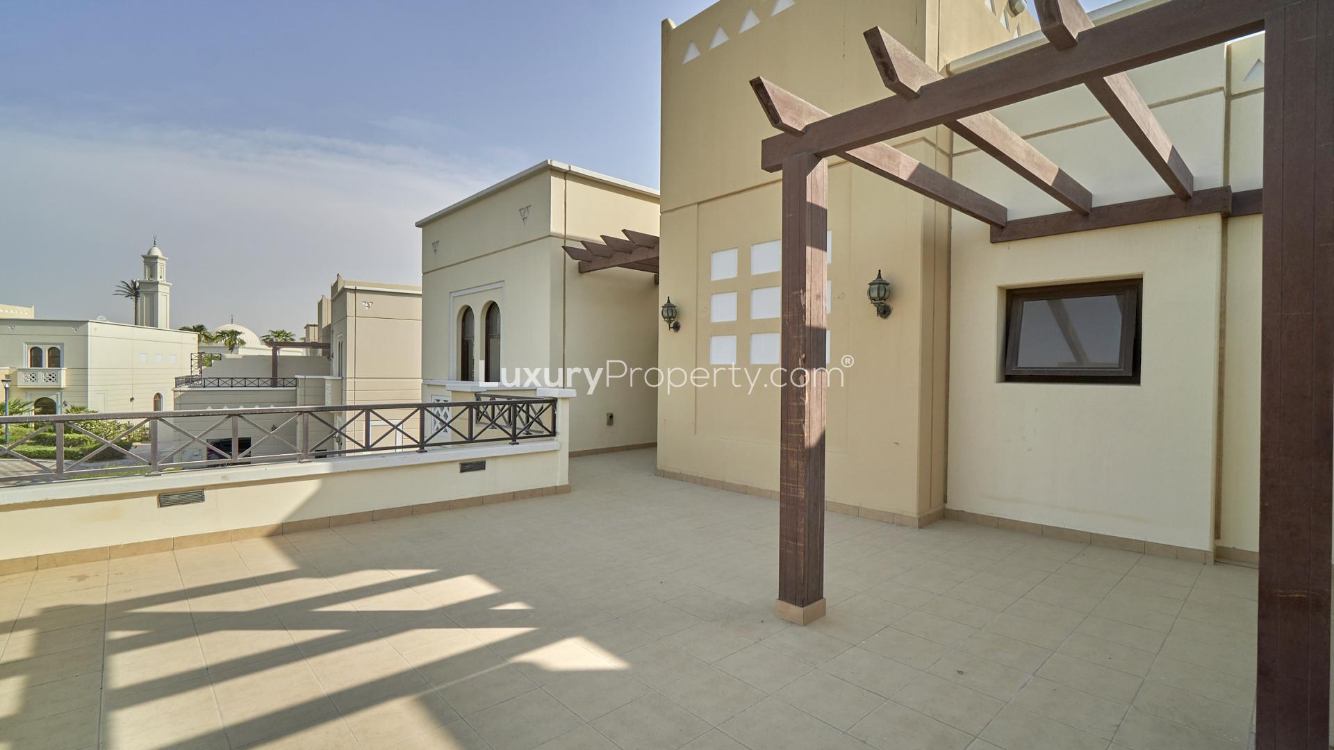 Luxurious swimming pool area in Naseem, Mudon townhouse community, surrounded by lush greenery