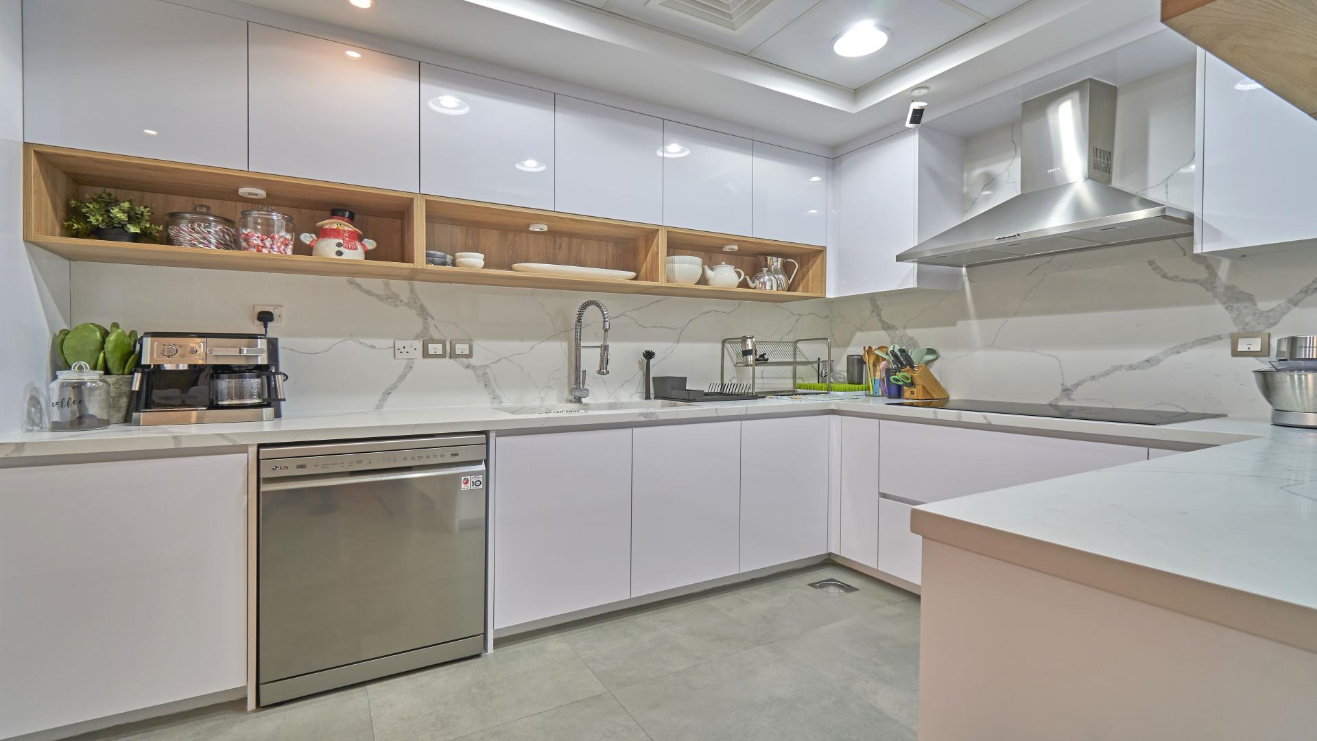 Modern kitchen in 4-bedroom townhouse, Mudon, featuring sleek cabinets and marble countertops