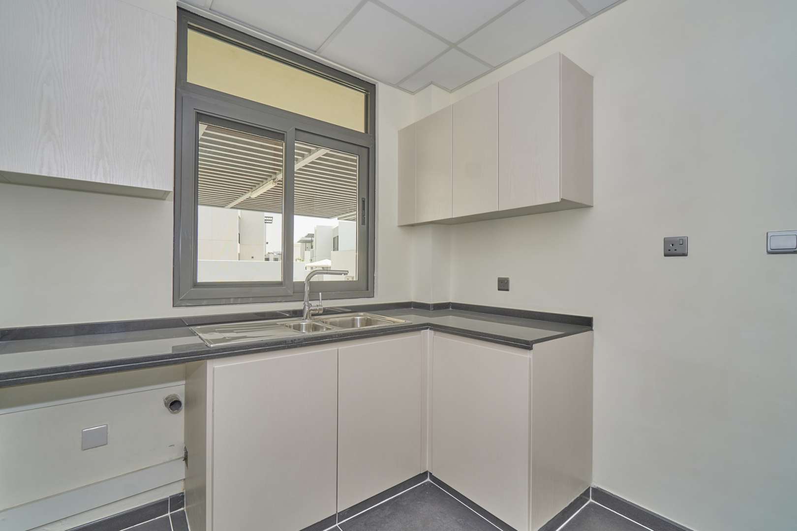 Modern kitchen with staircase view in 4-bedroom townhouse, Primrose, Damac Hills 2