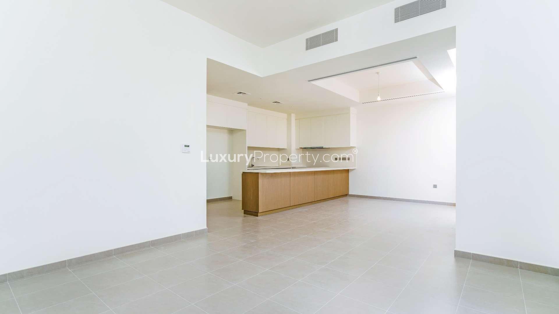 Modern kitchen and dining area in Arabian Ranches 2 townhouse, featuring sleek countertops and lighting