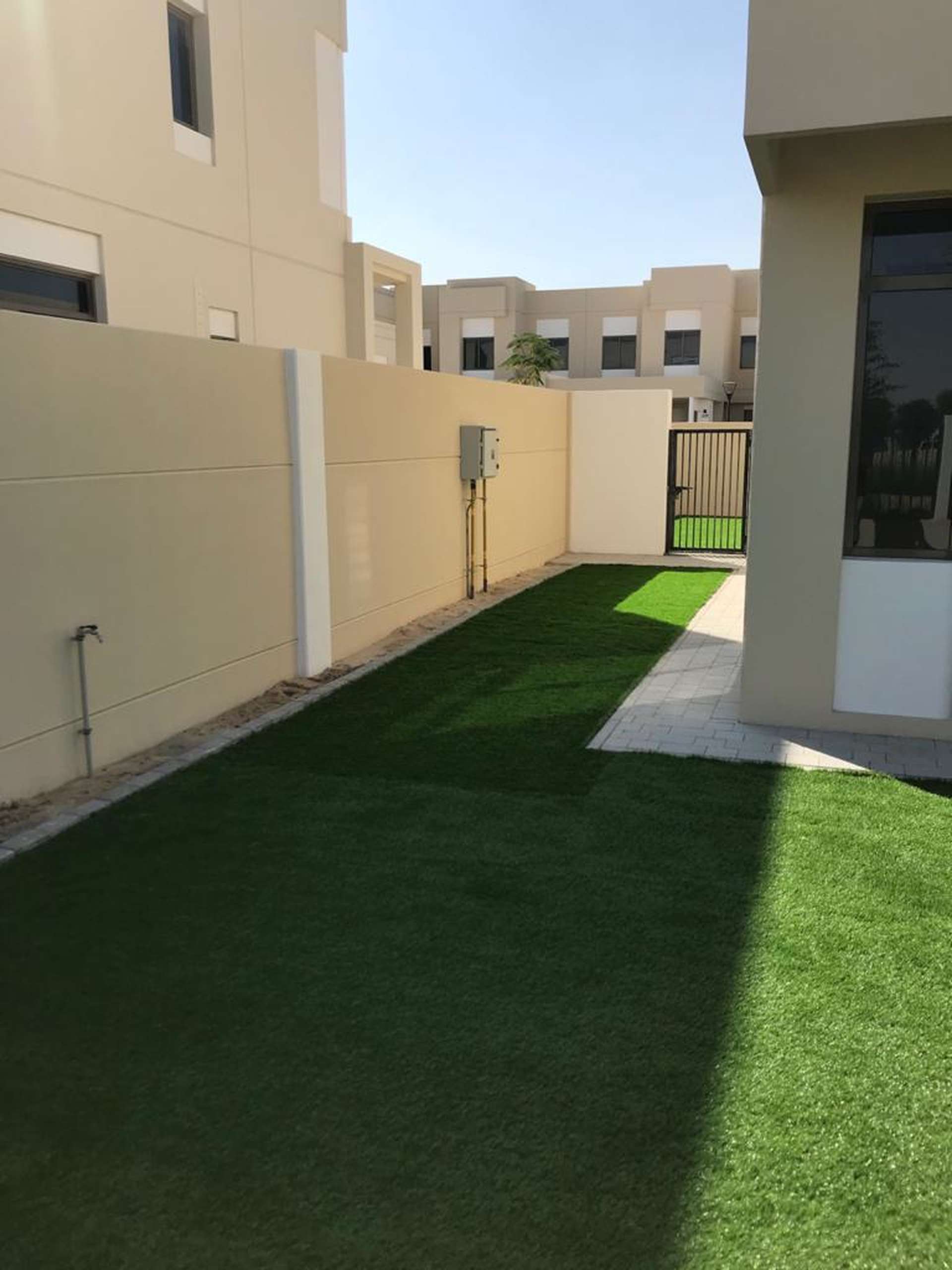 4-bedroom townhouse exterior in Safi, Town Square, Dubai, with lawn and modern design