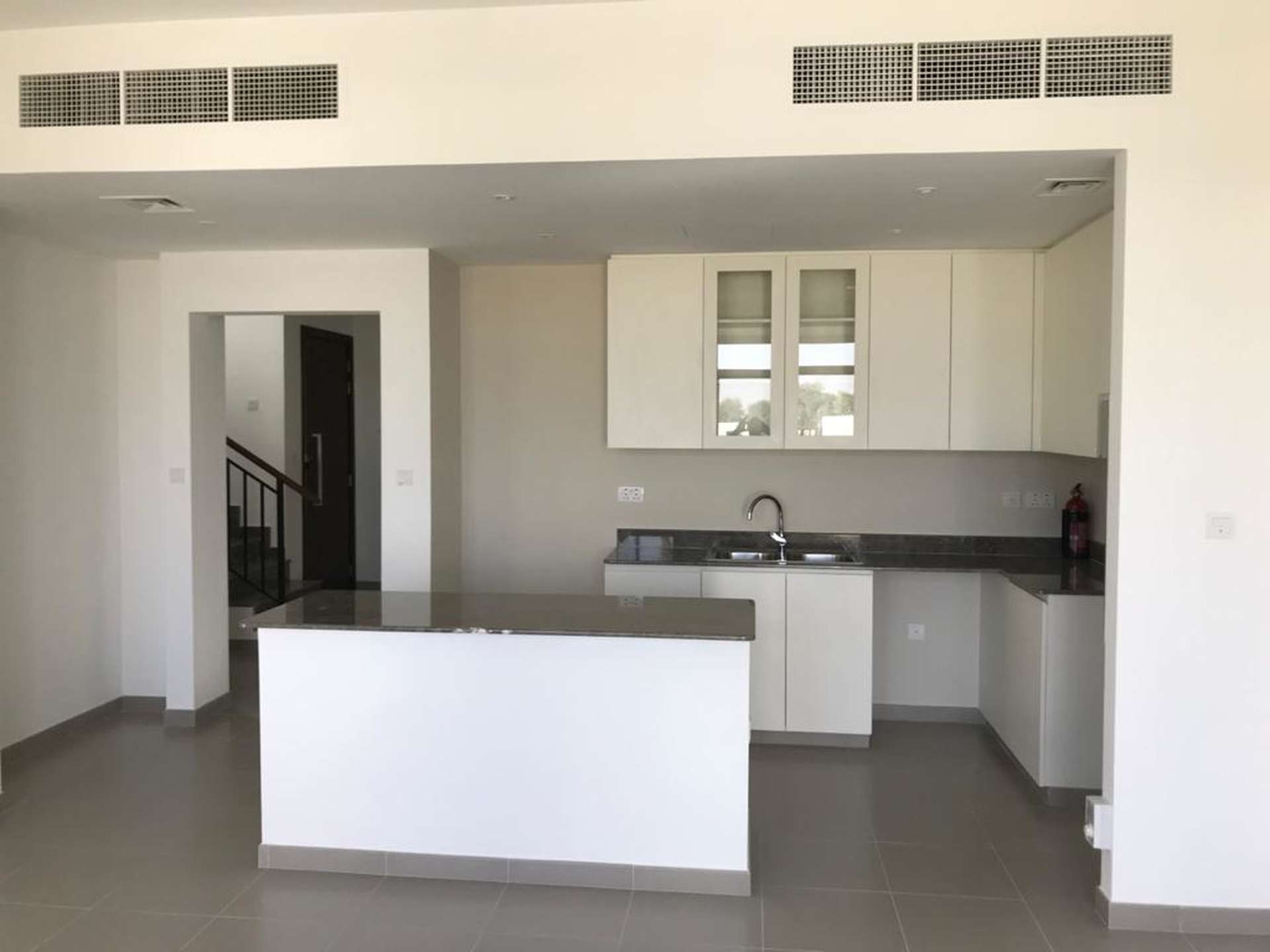 "Spacious backyard with green lawn in Safi Townhouse, Town Square, Dubai for sale.",Modern kitchen in 4-bedroom townhouse, Safi, Town Square, Dubai. Spacious layout and sleek design