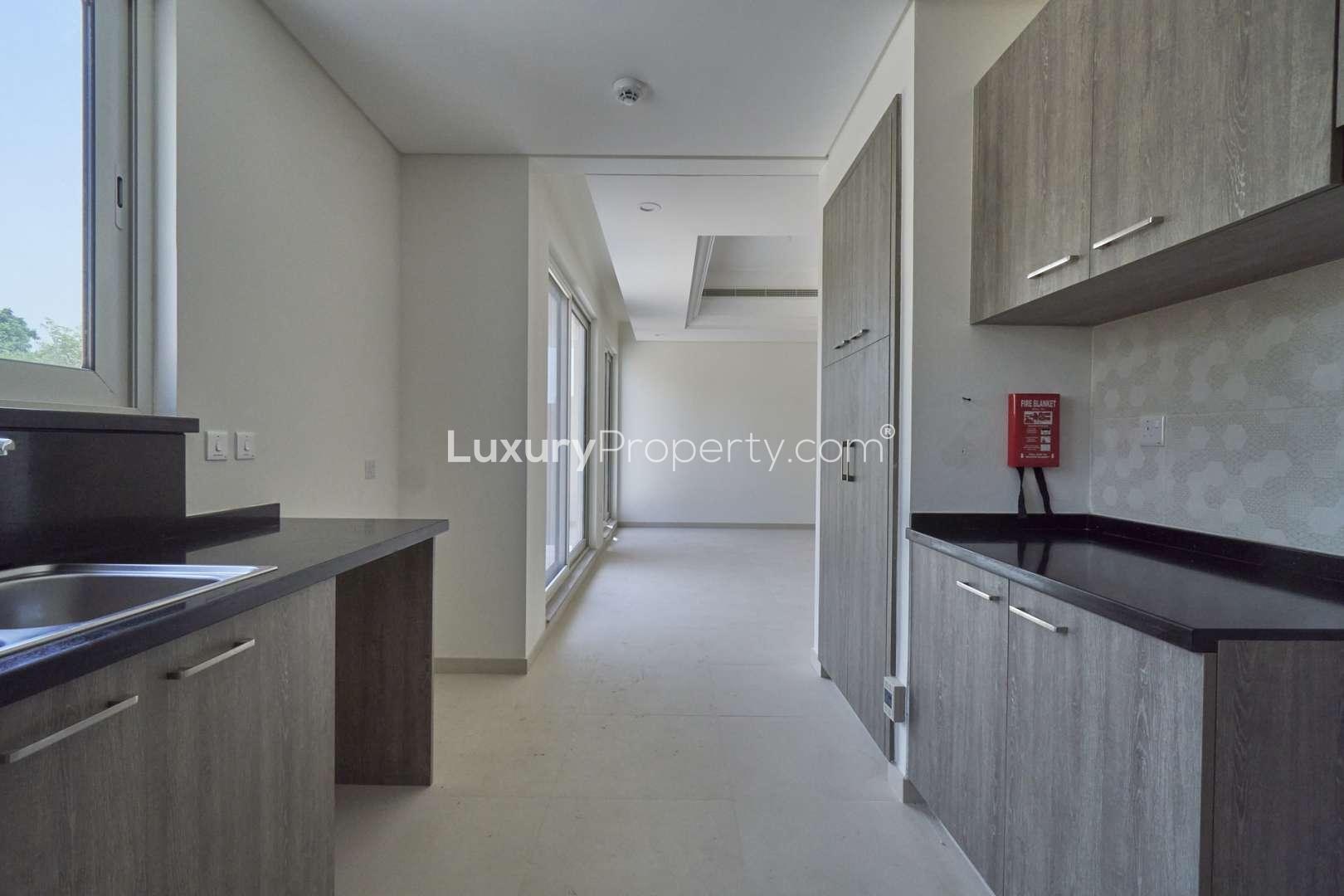 Modern kitchen in Marbella townhouse, Dubai Sports City, featuring sleek cabinetry and countertops