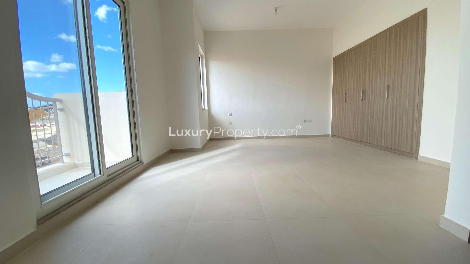 Modern kitchen with wooden cabinets in townhouse, Victory Heights, Dubai Sports City