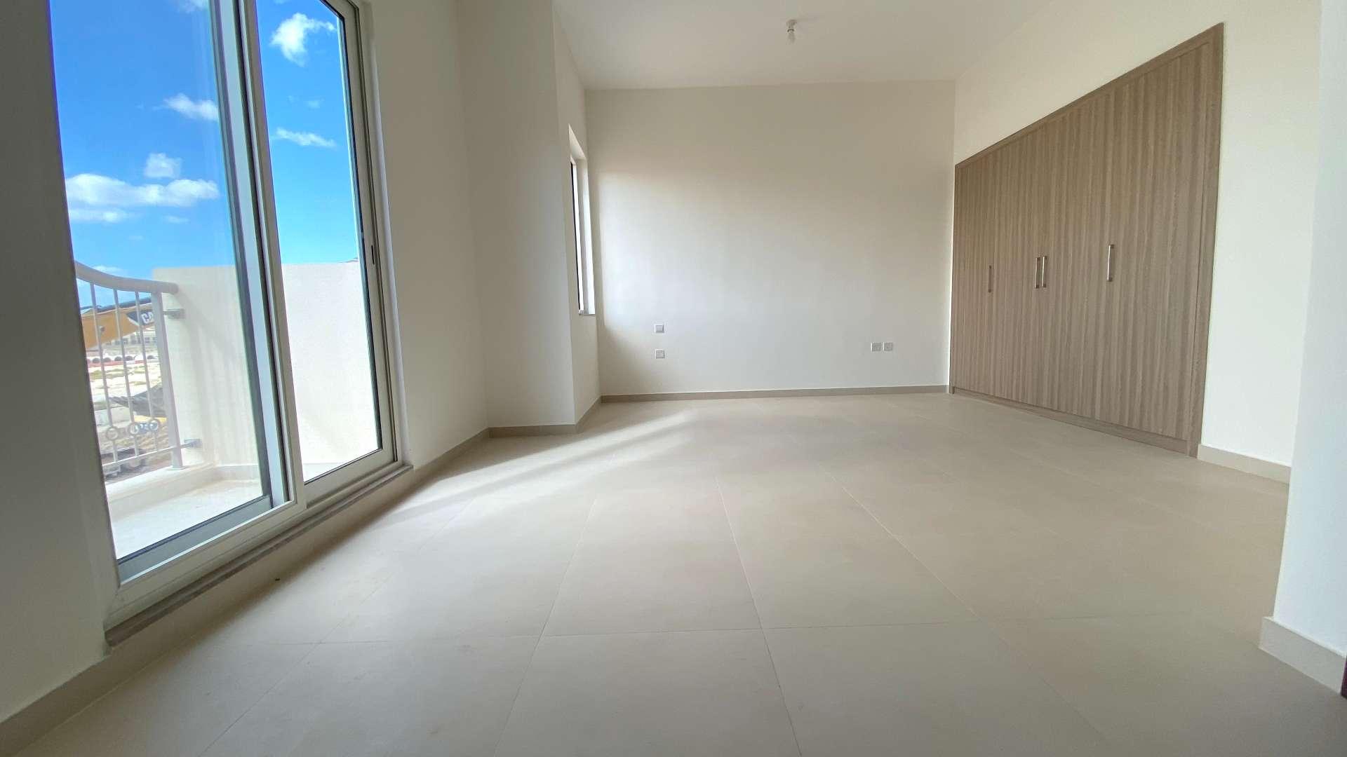 Modern kitchen with wooden cabinets in townhouse, Victory Heights, Dubai Sports City