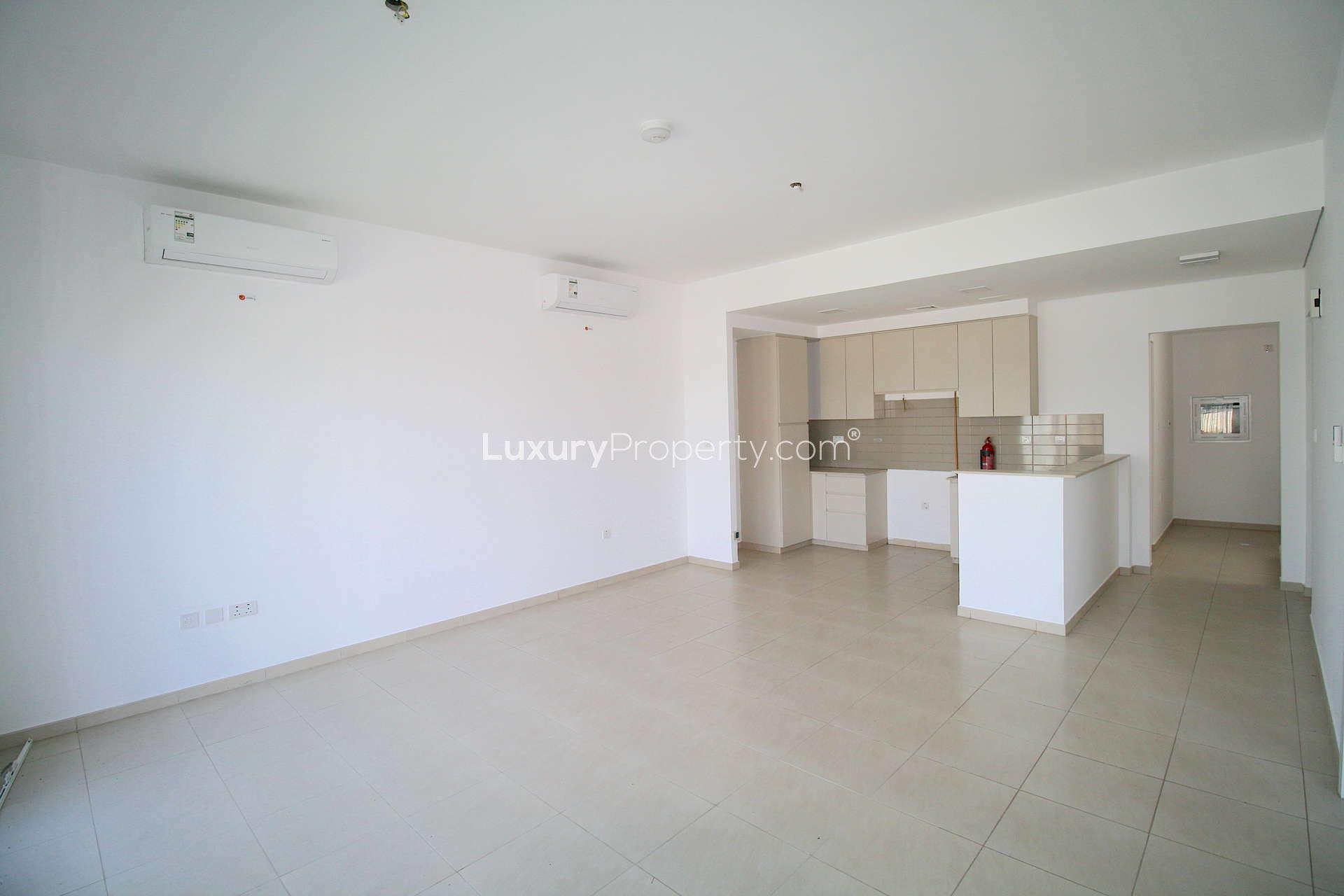 Modern kitchen and living area in Zahra Townhouse, Dubai Town Square, for sale