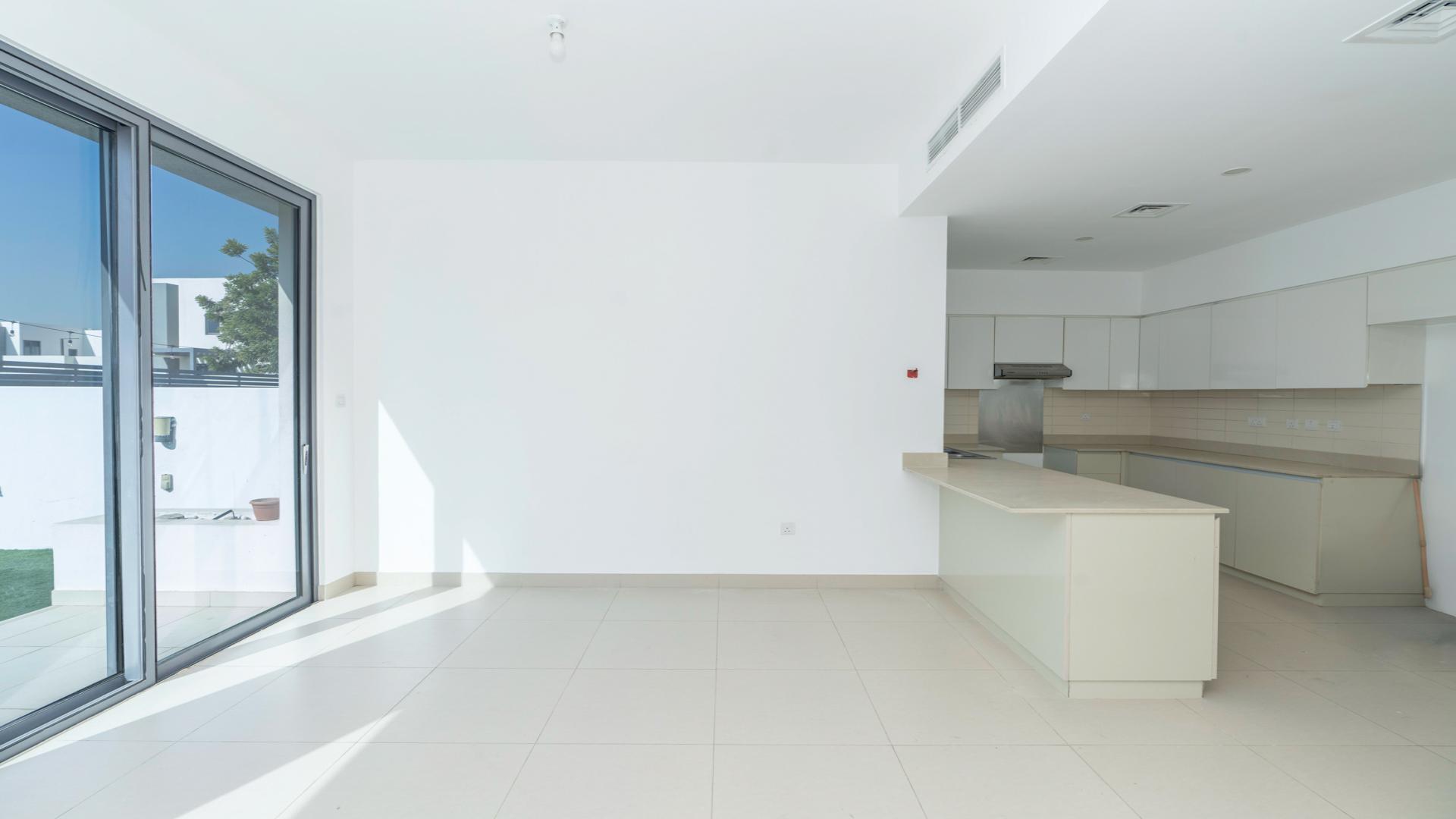 "Spacious living area with large windows in Maple 3 villa, Dubai Hills Estate.",Unfurnished kitchen and living area in Dubai Hills Estate villa for rent, Maple 3