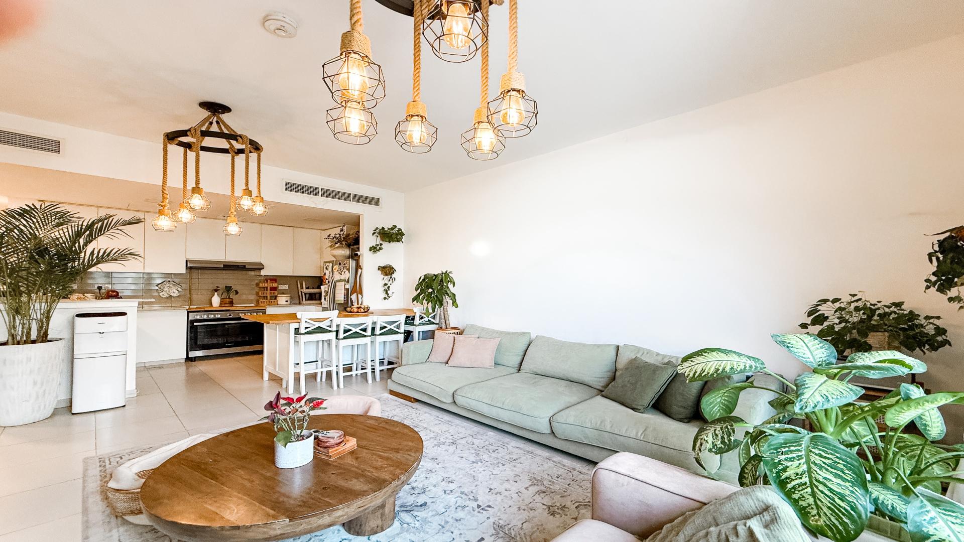 Spacious living room in Noor Townhouses villa, featuring modern decor and natural light