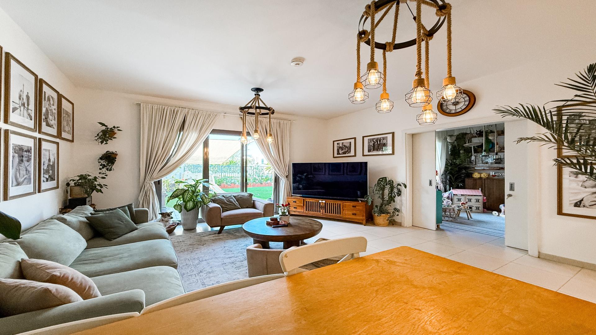 Modern living room in Noor Townhouses villa, featuring cozy seating and garden view
