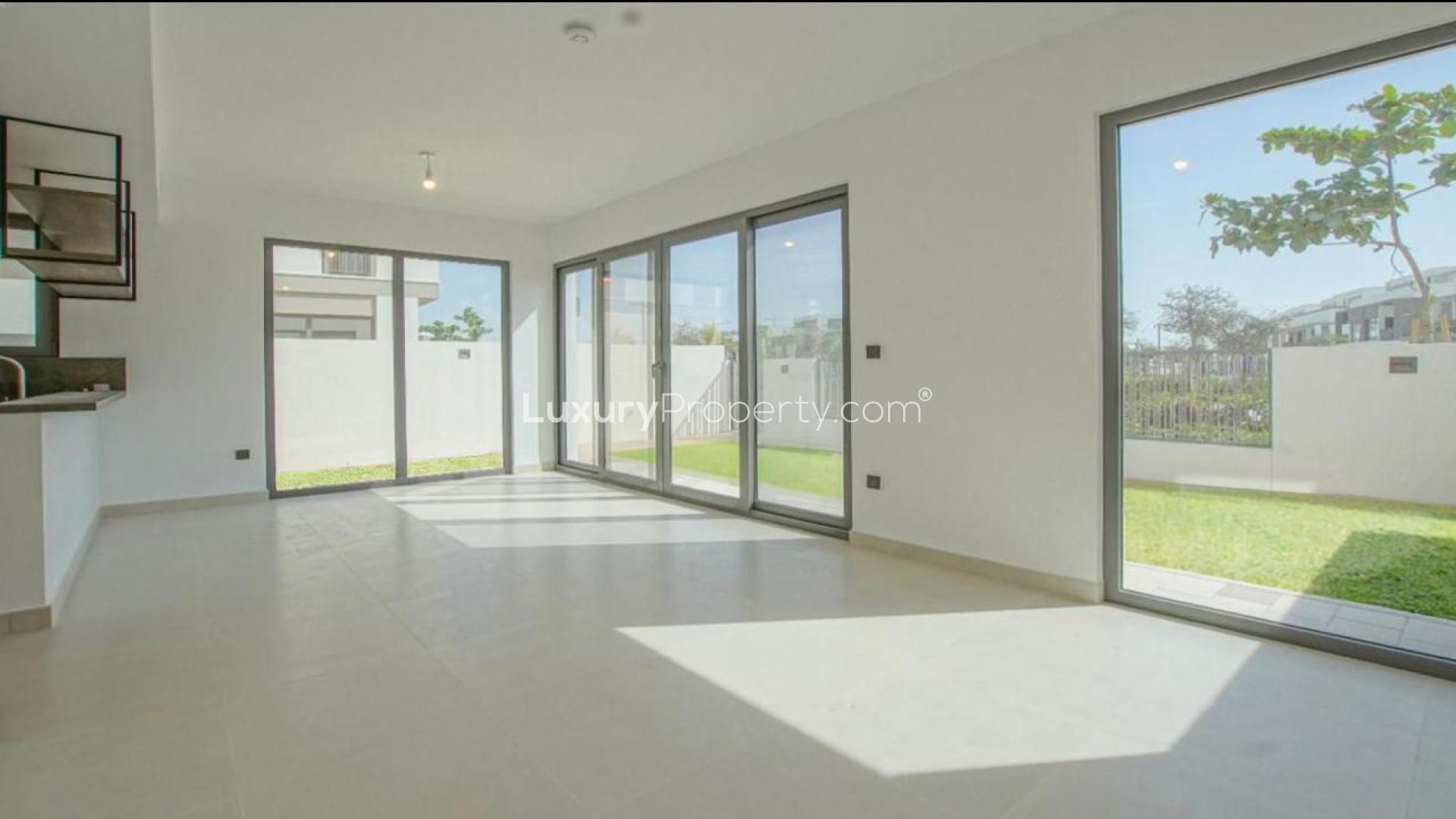 Brand new single-row villa exterior with green lawn in Aura 2, Tilal Al Ghaf