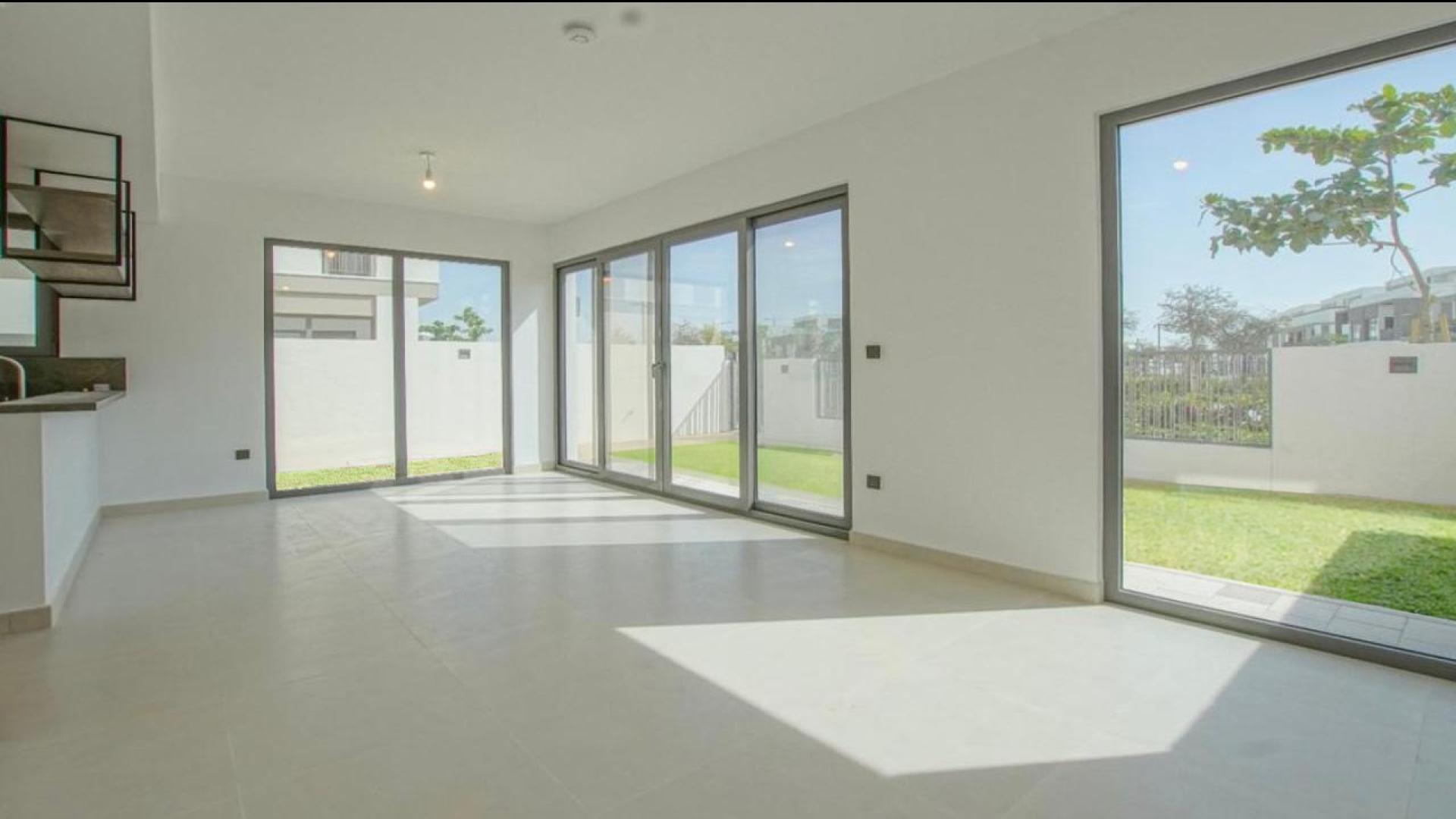 Brand new single-row villa exterior with green lawn in Aura 2, Tilal Al Ghaf