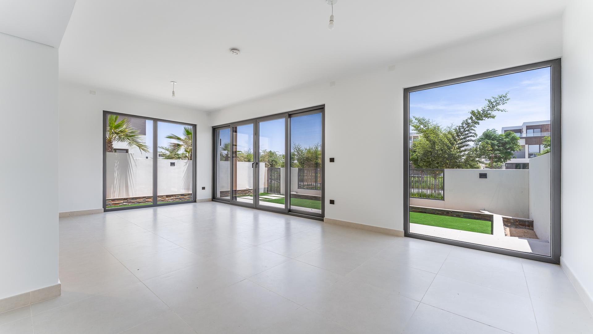 Bright living room with large windows overlooking garden in Aura, Tilal Al Ghaf villa