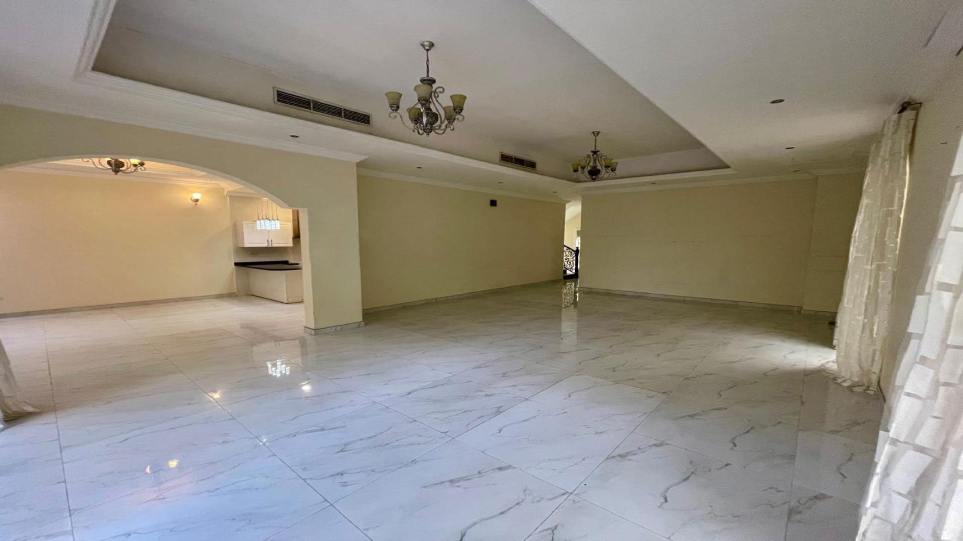 Spacious living room in 4-bedroom villa, The Aldea, with large windows and elegant chandeliers