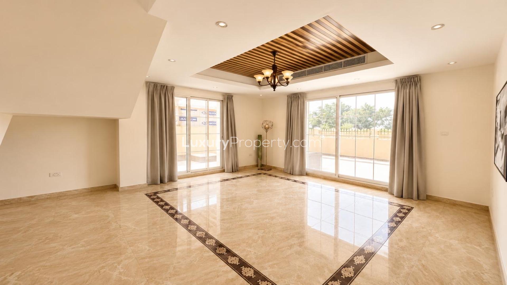Spacious living room with chandelier and large windows in The Aldea villa for rent
