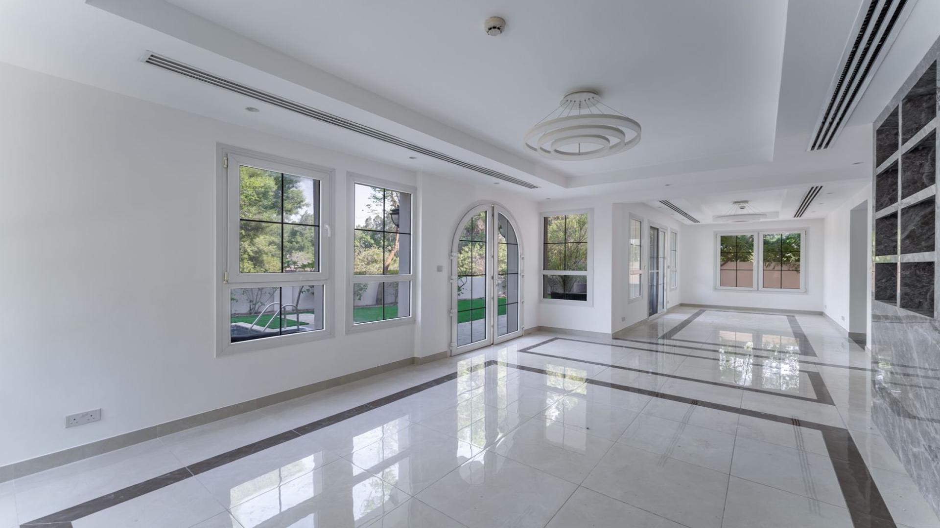 Upgraded villa interior with large windows overlooking garden in Jumeirah Golf Estates, Earth community