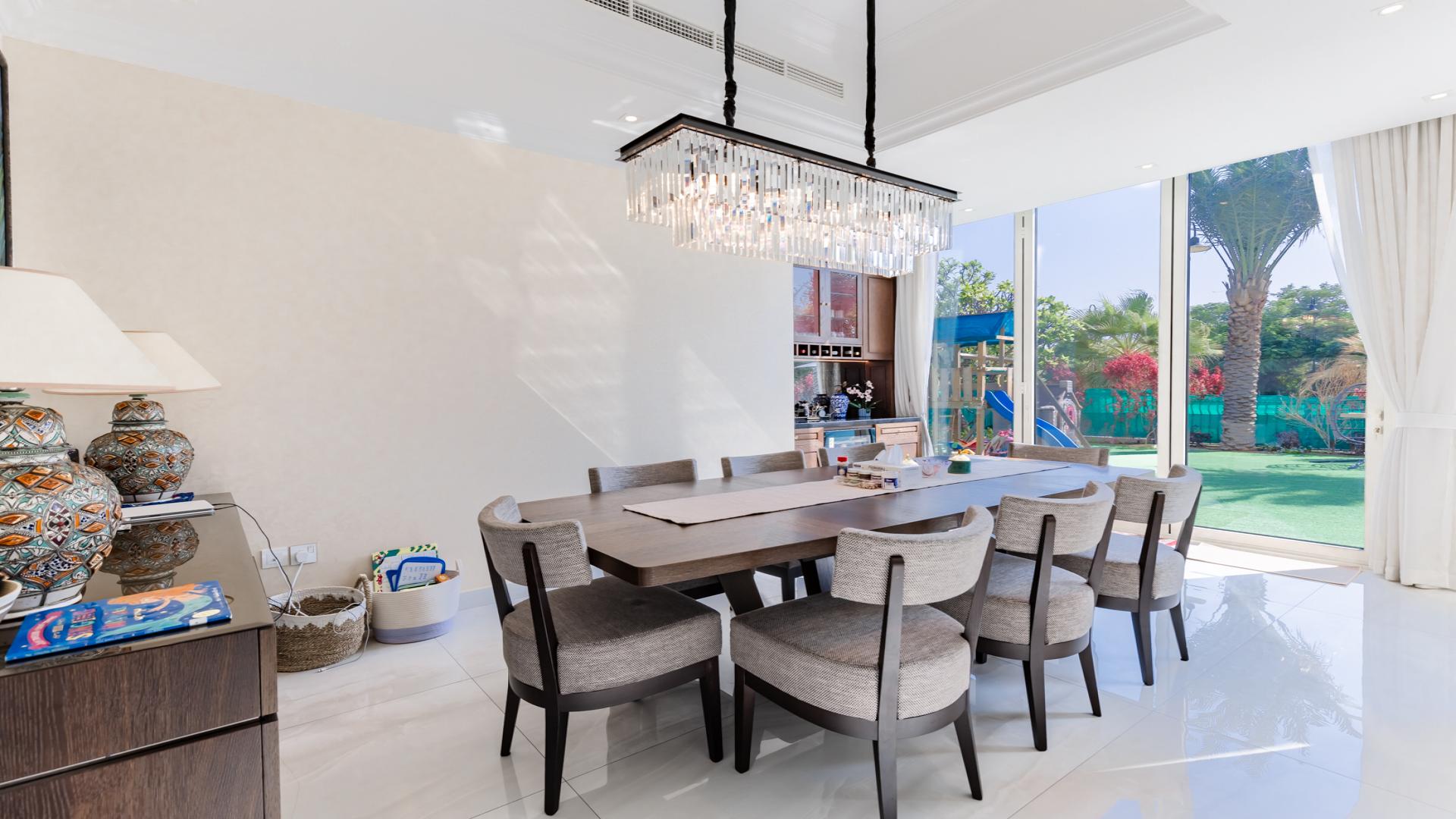 Dining room in renovated villa, Jumeirah Islands, with garden view and elegant chandelier