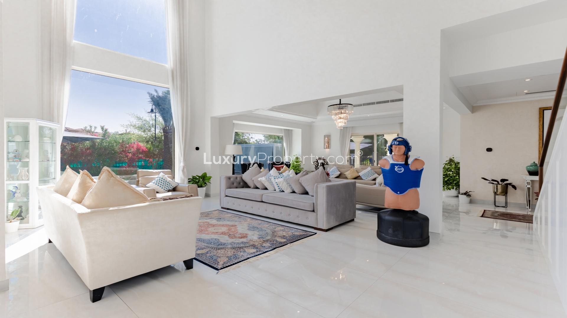 Modern villa living room with elegant decor, large windows, and plush seating in Jumeirah Islands