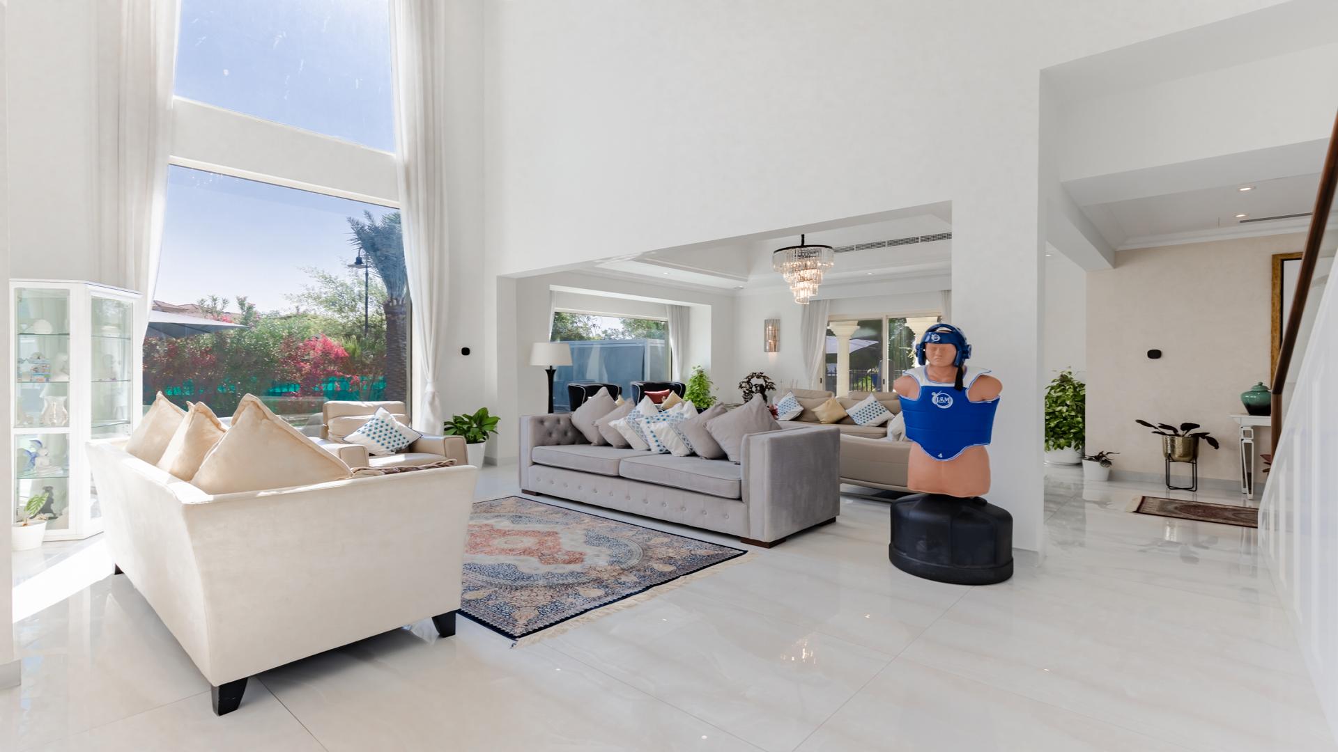 Modern villa living room with elegant decor, large windows, and plush seating in Jumeirah Islands