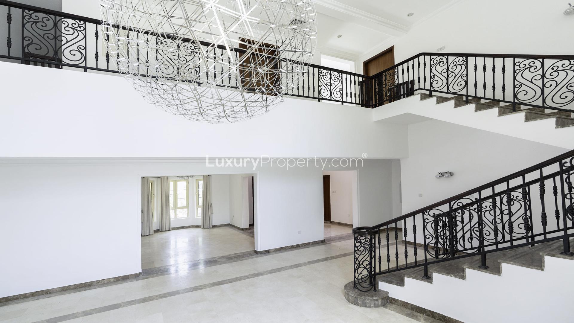 "Luxury Mediterranean villa with private pool in Jumeirah Islands, available for rent.",Open plan living area with elegant staircase in Jumeirah Islands villa for rent