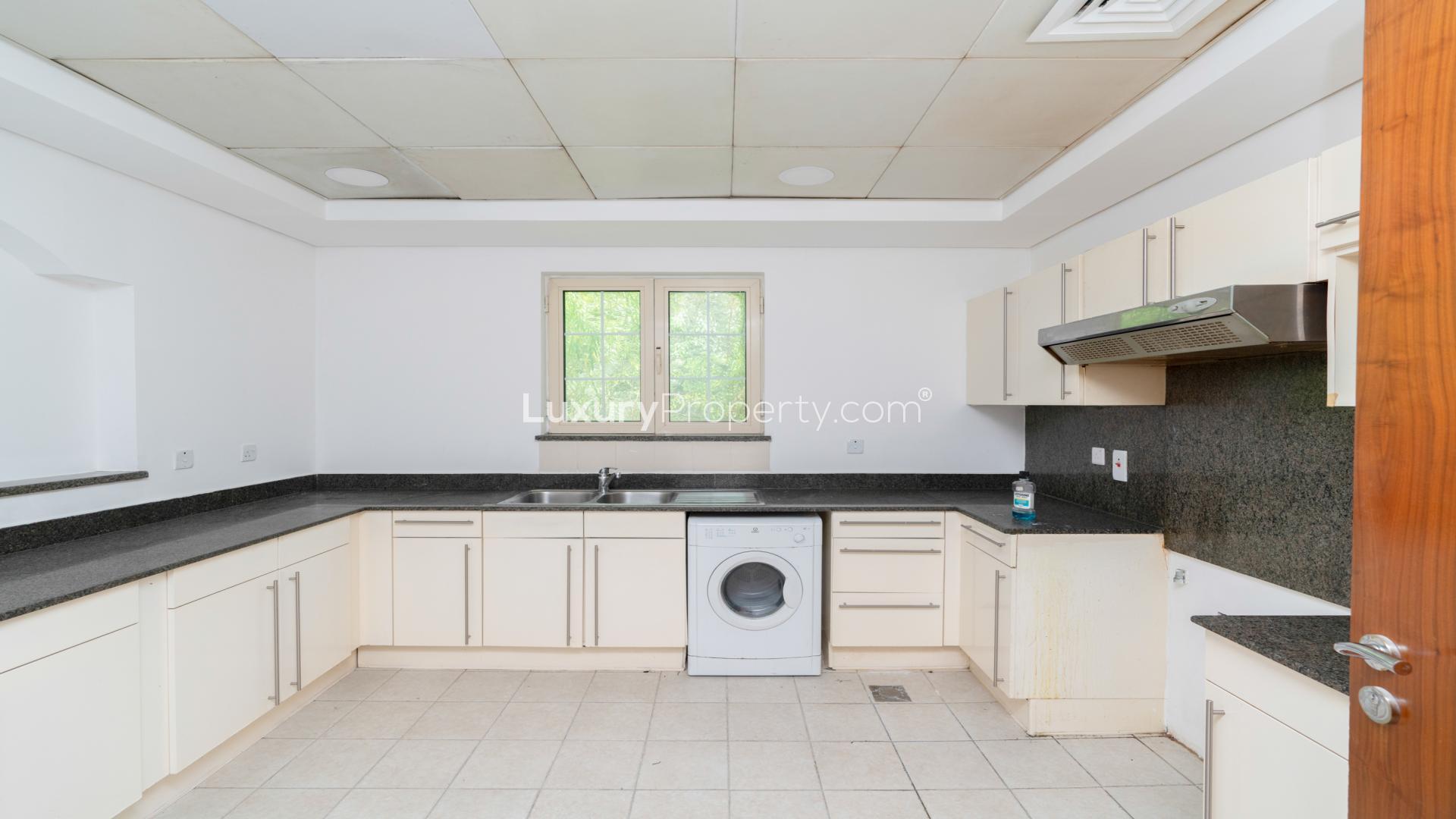 "Spacious interior of Jumeirah Islands villa with elegant staircase and iron railing.","Modern kitchen in luxury Jumeirah Islands villa, featuring sleek countertops and ample cabinetry.",Empty luxury villa room with large windows and pool view in Jumeirah Islands