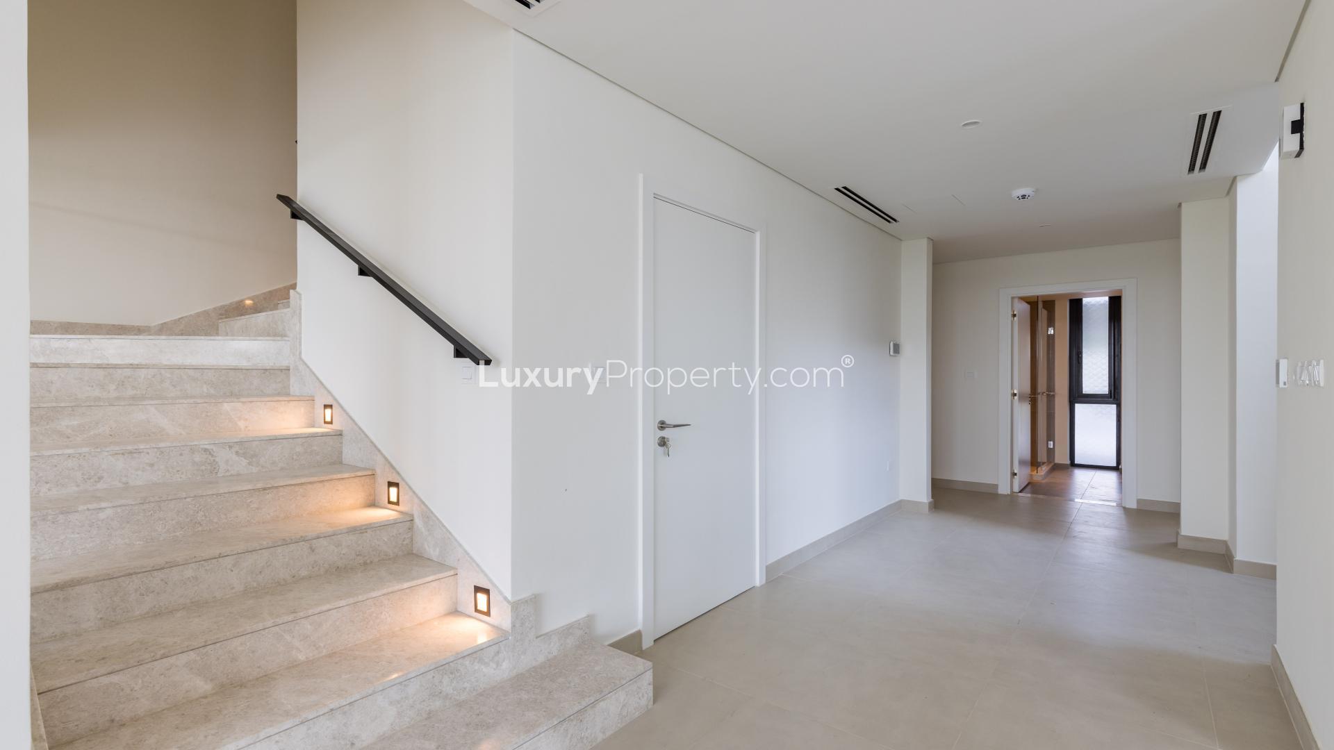 Modern hallway in Dubai Hills Estate villa, featuring open doors and sleek design elements