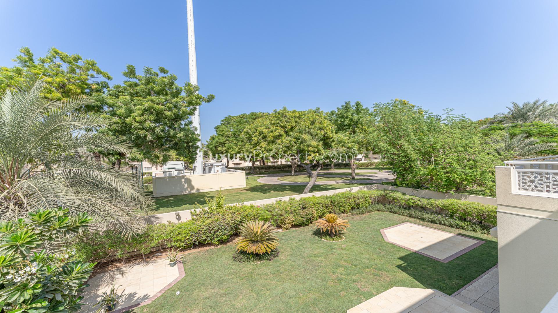 Empty living room with chandeliers and large windows in Meadows 8 villa for rent