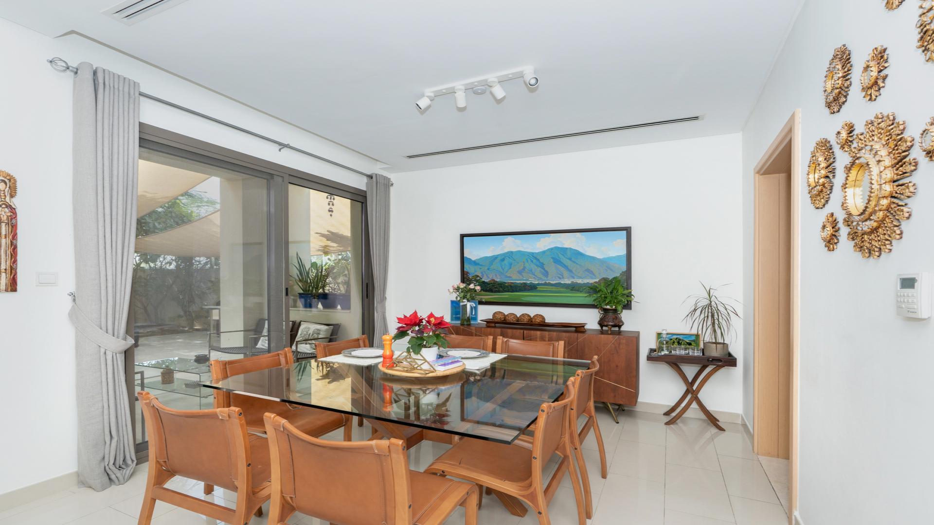 "Spacious living room with modern decor in 4-bedroom villa, Azalea, Arabian Ranches 2.",Dining area in 4-bedroom villa, Azalea, Arabian Ranches 2, with glass table and decor