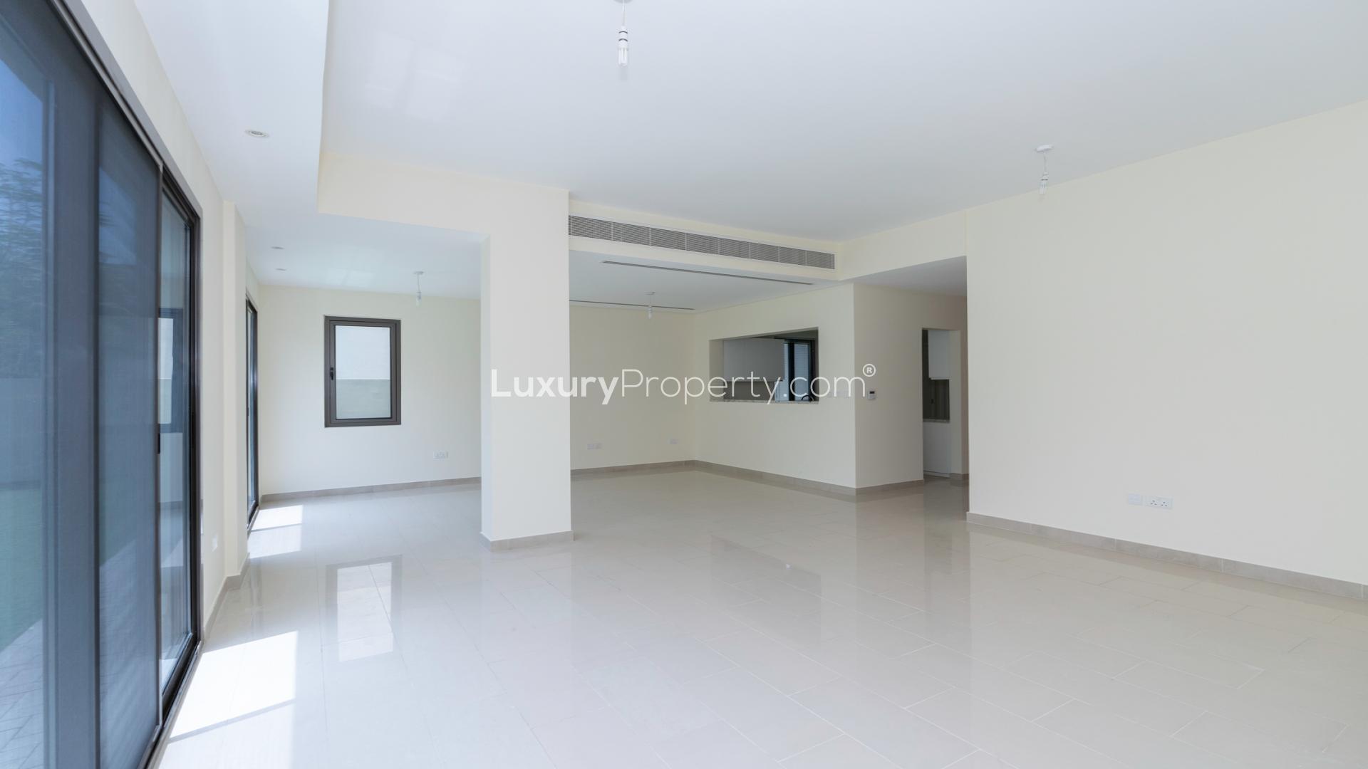 Spacious living room in Azalea Villa, Arabian Ranches 2, with large windows and garden view