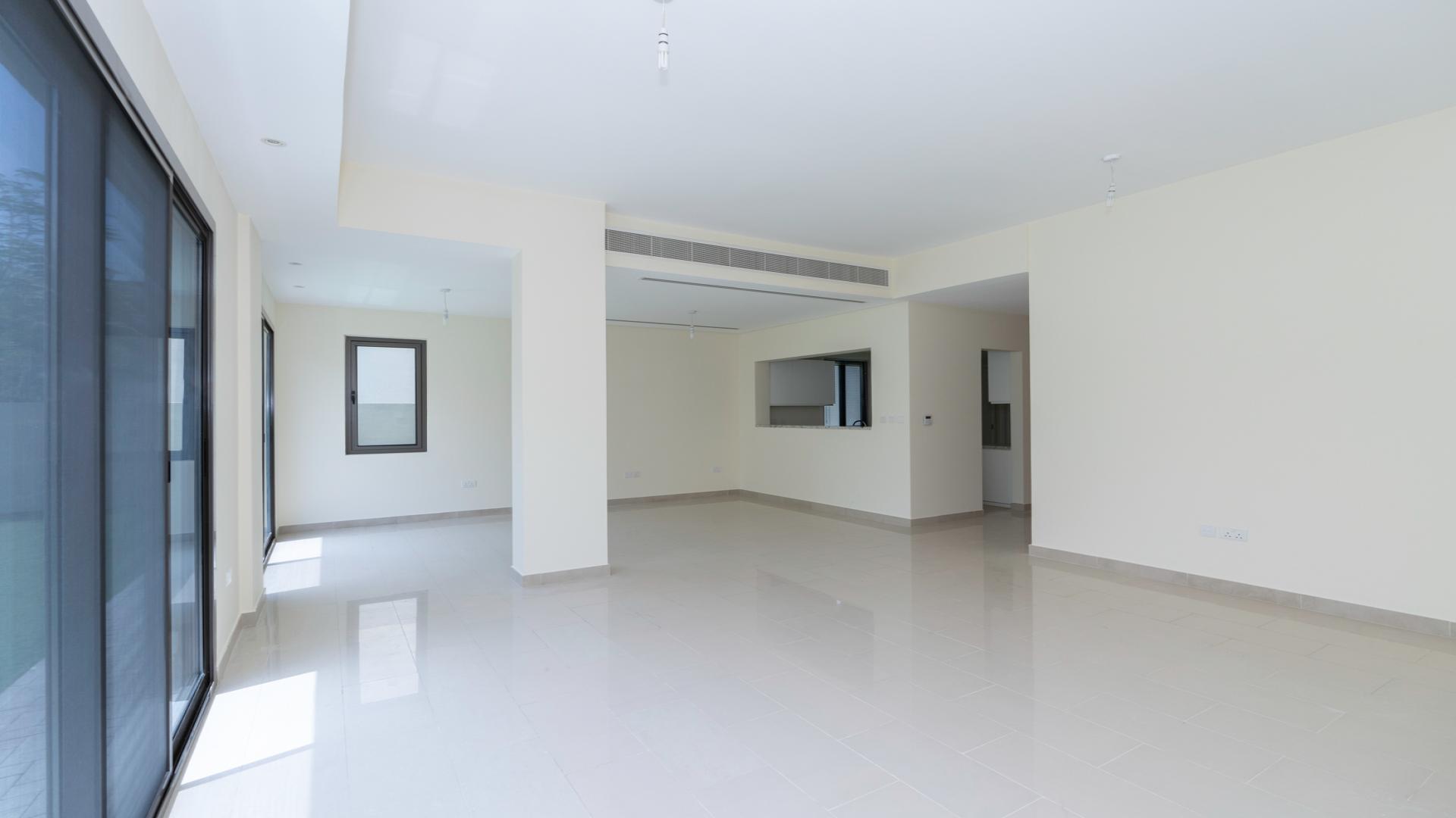 Spacious living room in Azalea Villa, Arabian Ranches 2, with large windows and garden view