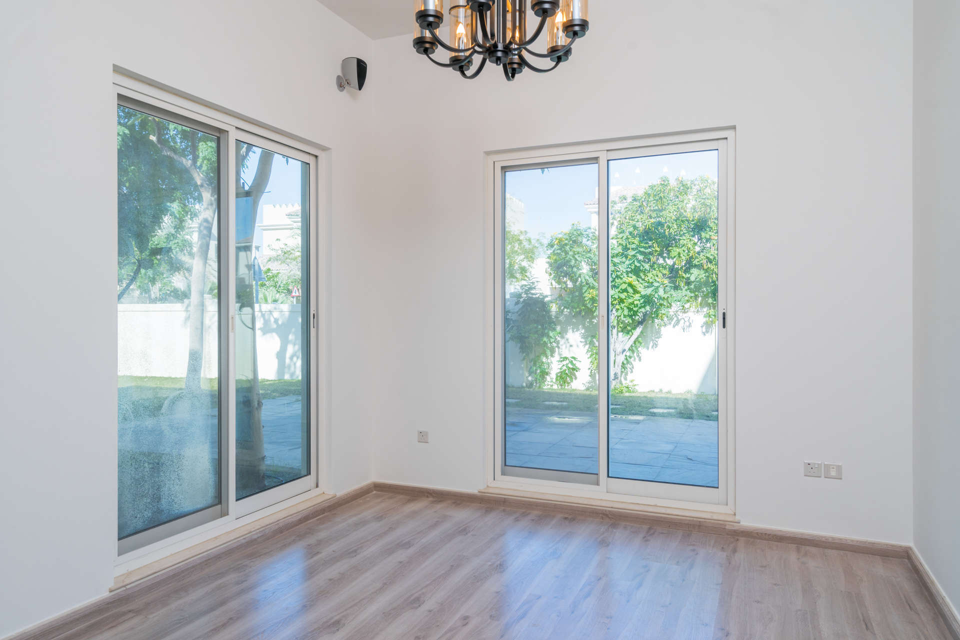 Bright living room with large windows overlooking pool in Victory Heights villa, Dubai Sports City