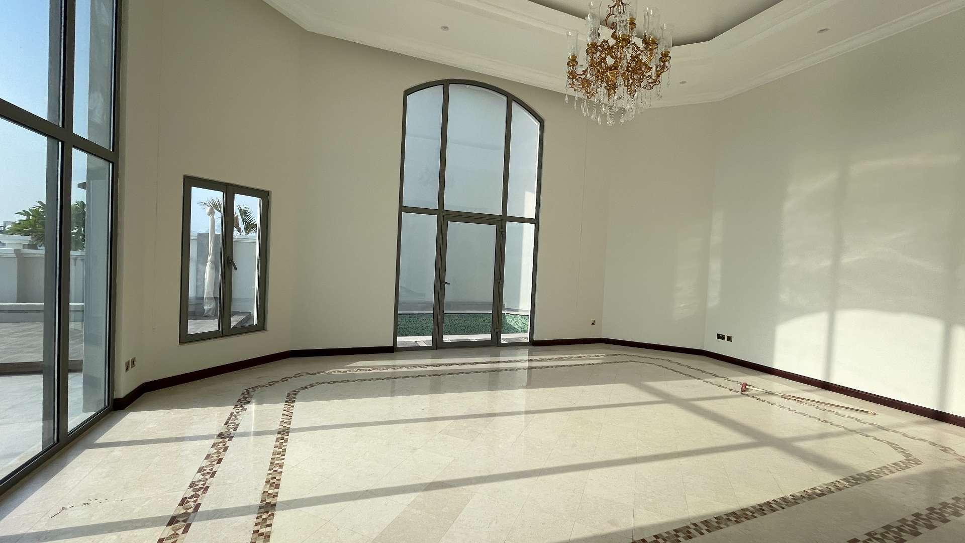 Spacious living room in revamped Garden Home Villa, Palm Jumeirah, with large windows and chandelier