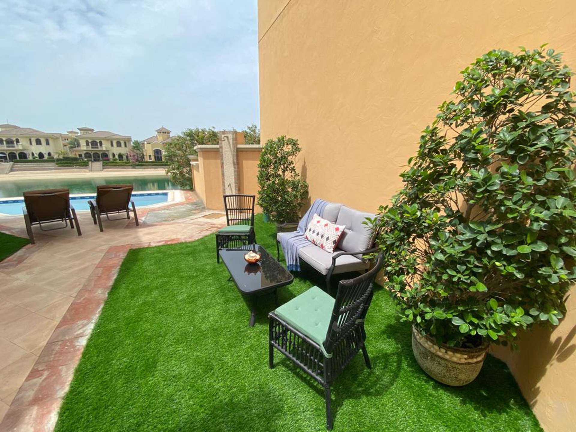 Elegant living room with plush sofa, large window, and garden view in Palm Jumeirah villa